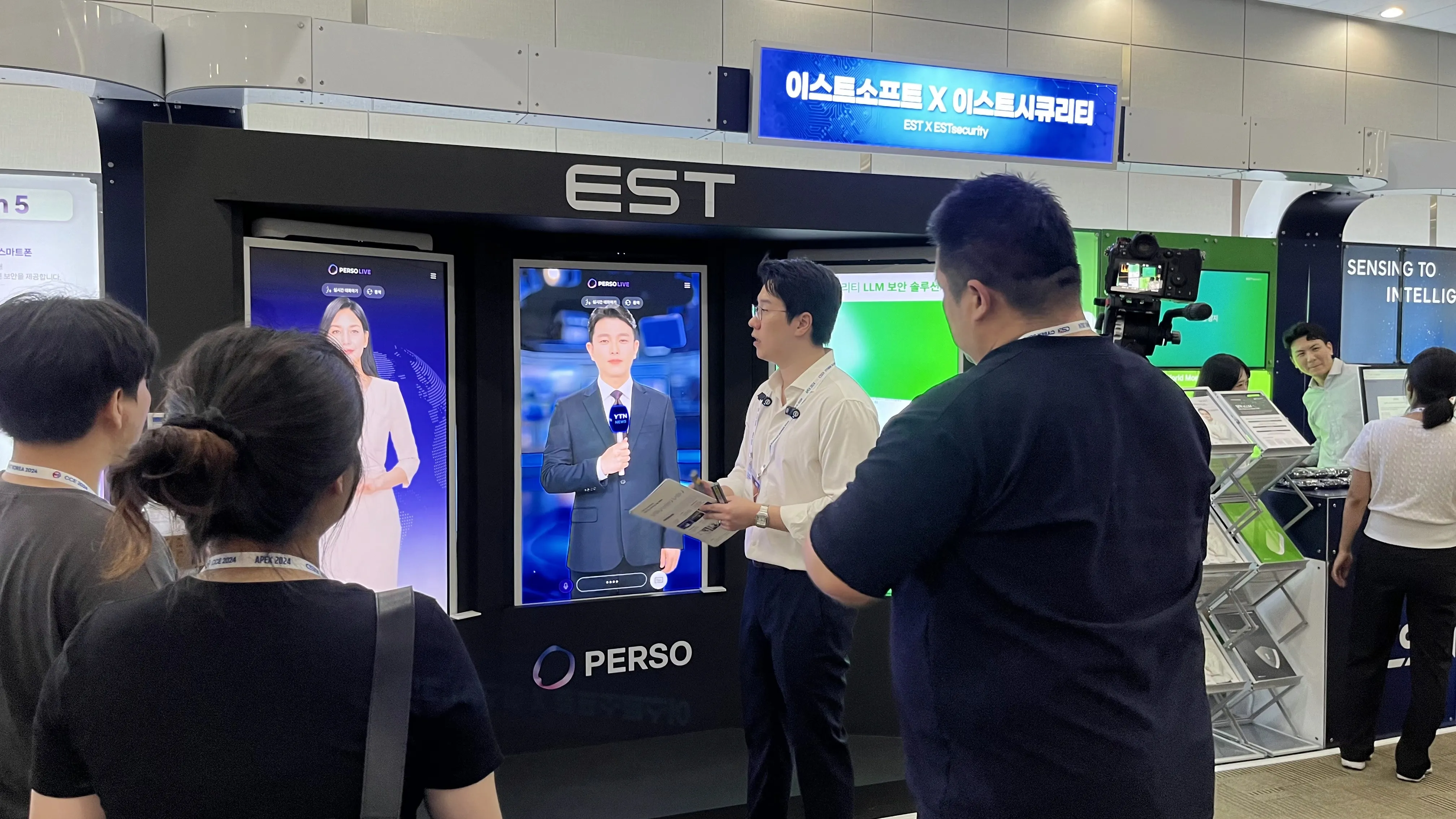 Attendees observing a demonstration of PERSO AI Human Kiosks at the joint ESTsoft and ESTsecurity booth