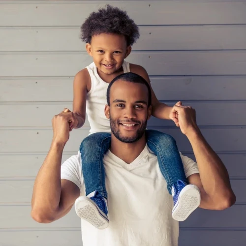 Smiling father holding his young son on his shoulders, serving families in Coburg and Melbourne's inner north.