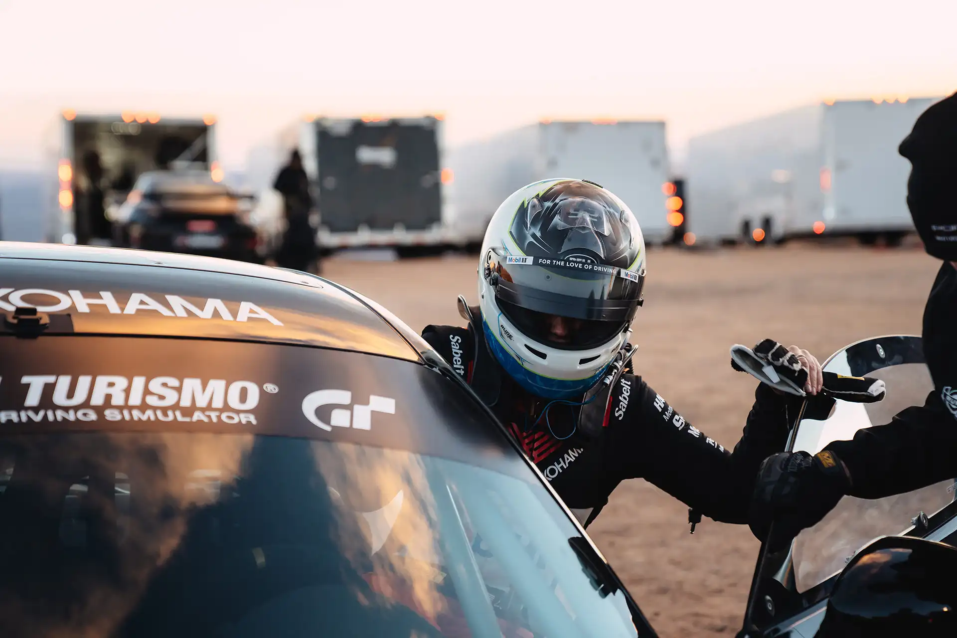 Loni Unser climbing out of her red Acura race car.