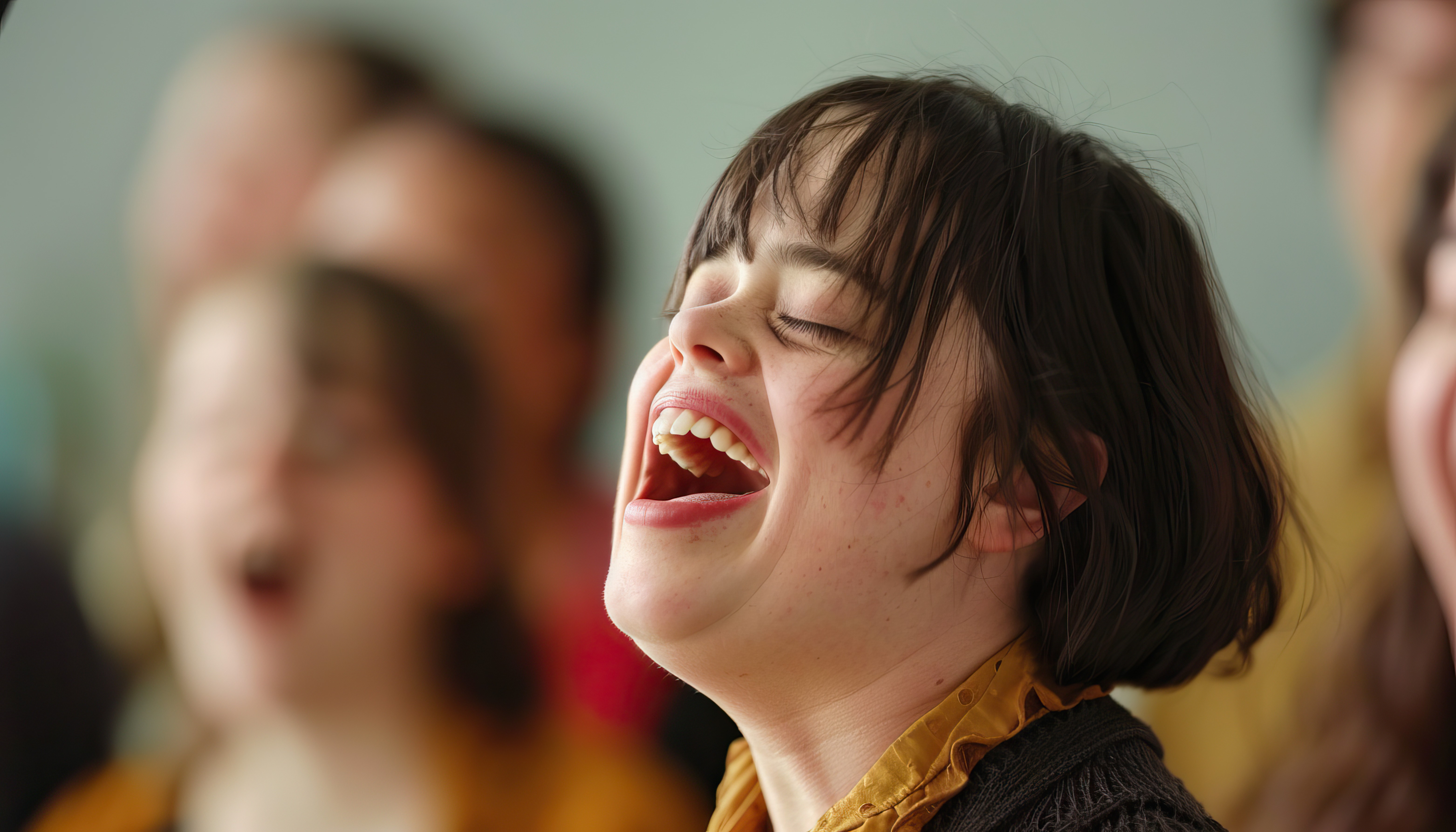 A smiling woman singing passionately on stage under bright lighting, with a blurred audience in the background."