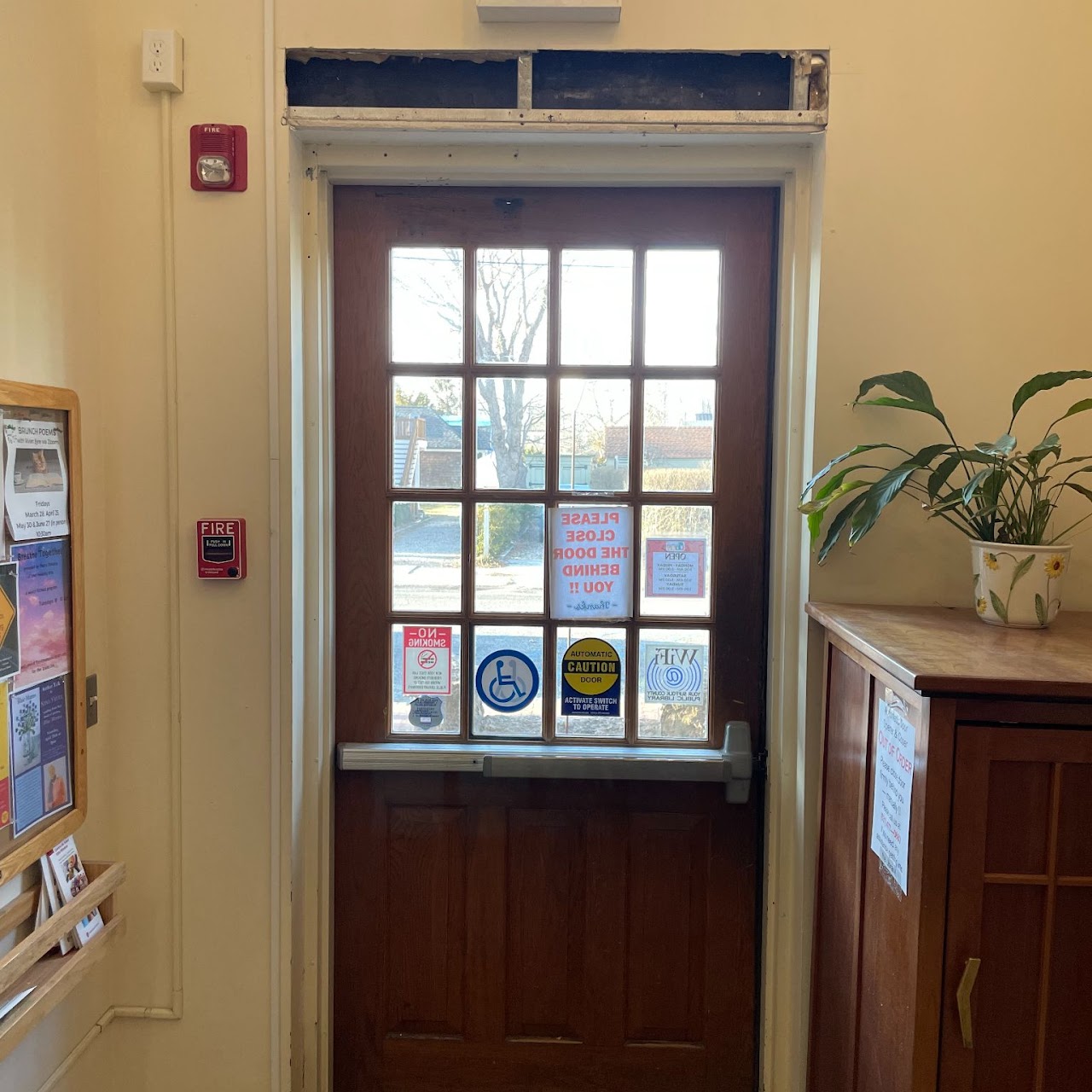 Commercial entry door with damaged transom area above the frame