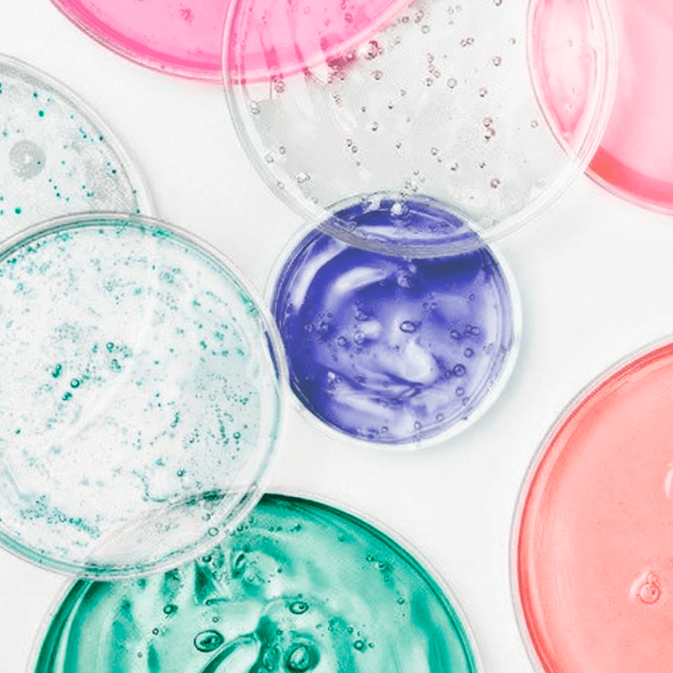 Balea Beauty Expert Wirkstoff-Inszenierung – Petrischalen mit Gel-Texturen in Pink, Koralle, Türkis, Mint und Violett, Closeup im Lab-Look.