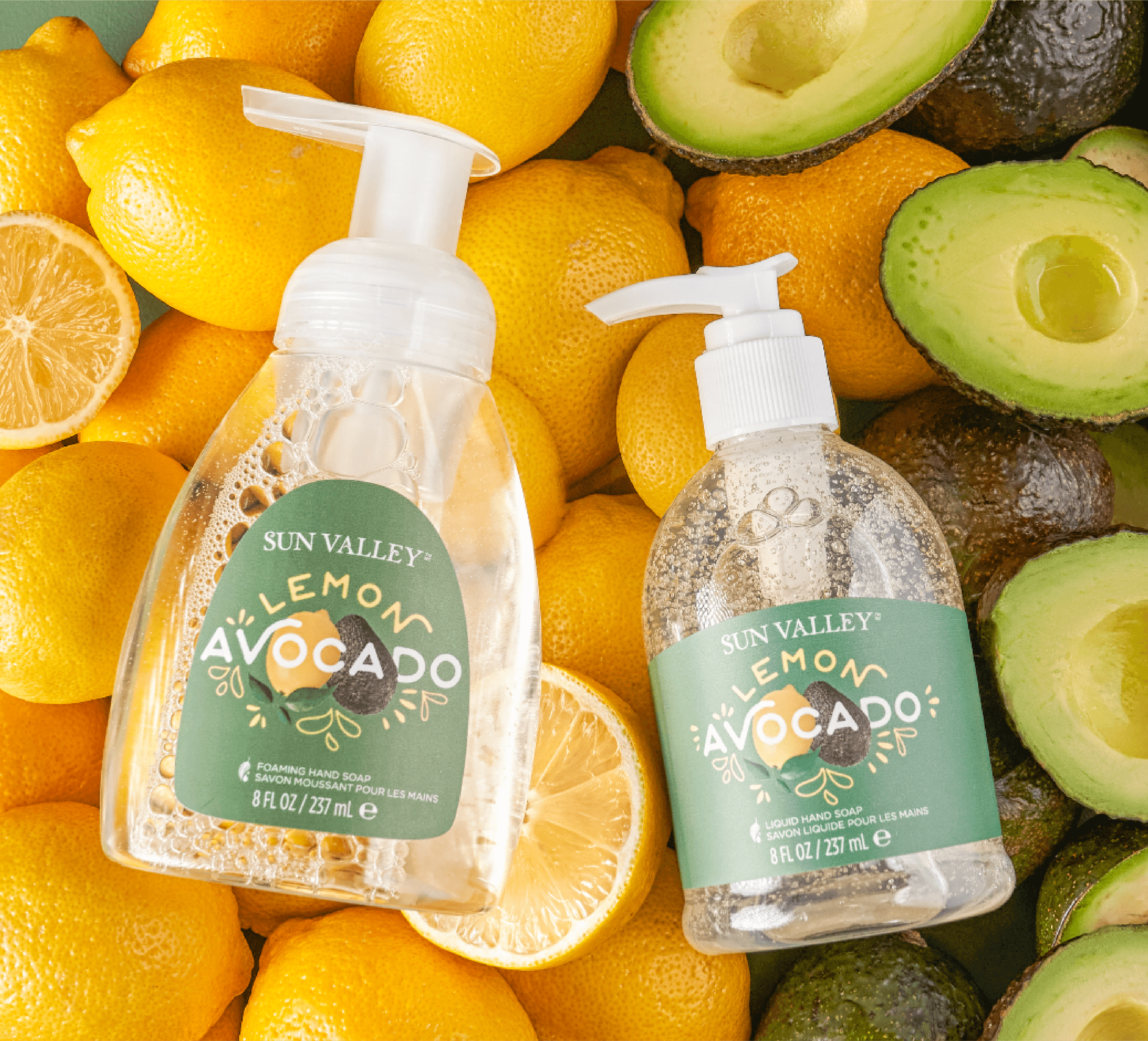 Person wearing black clothing carrying a black tote bag with a green globe-like geometric symbol, standing against a concrete wall in sunlight and shadow.