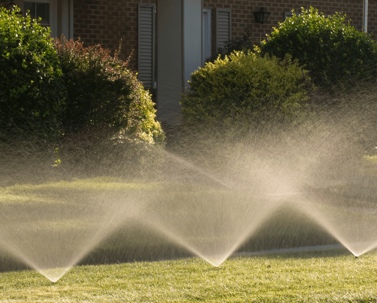 Advanced irrigation system installation by Elite Landscaping DFW, showcasing a team of professionals setting up efficient watering equipment in a lush, well-maintained garden in Dallas-Fort Worth.