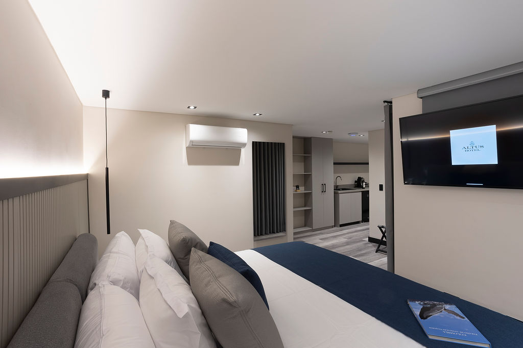 Hotel moderno en Laureles Medellín, habitación Altus Garden con ventanales y luz natural frente a muro verde natural y diseño de bienestar