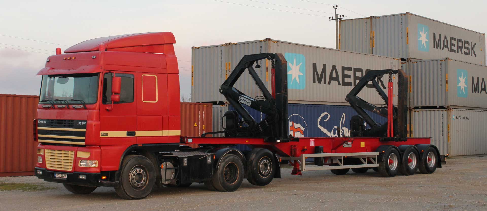 Red DAF sideloader truck lifting a Maersk container