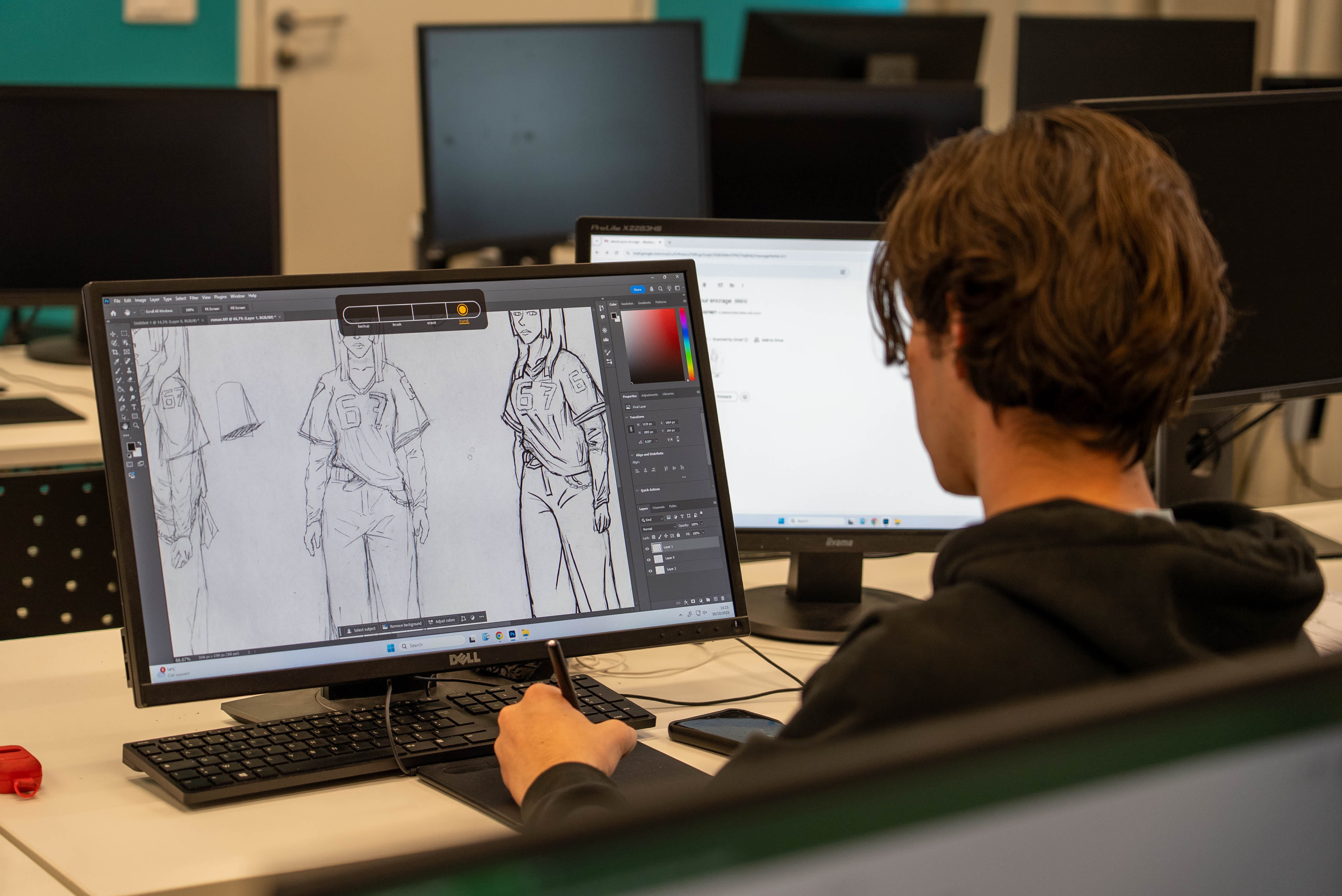 Étudiant utilisant une tablette graphique pour créer des illustrations numériques sur écran ordinateur
