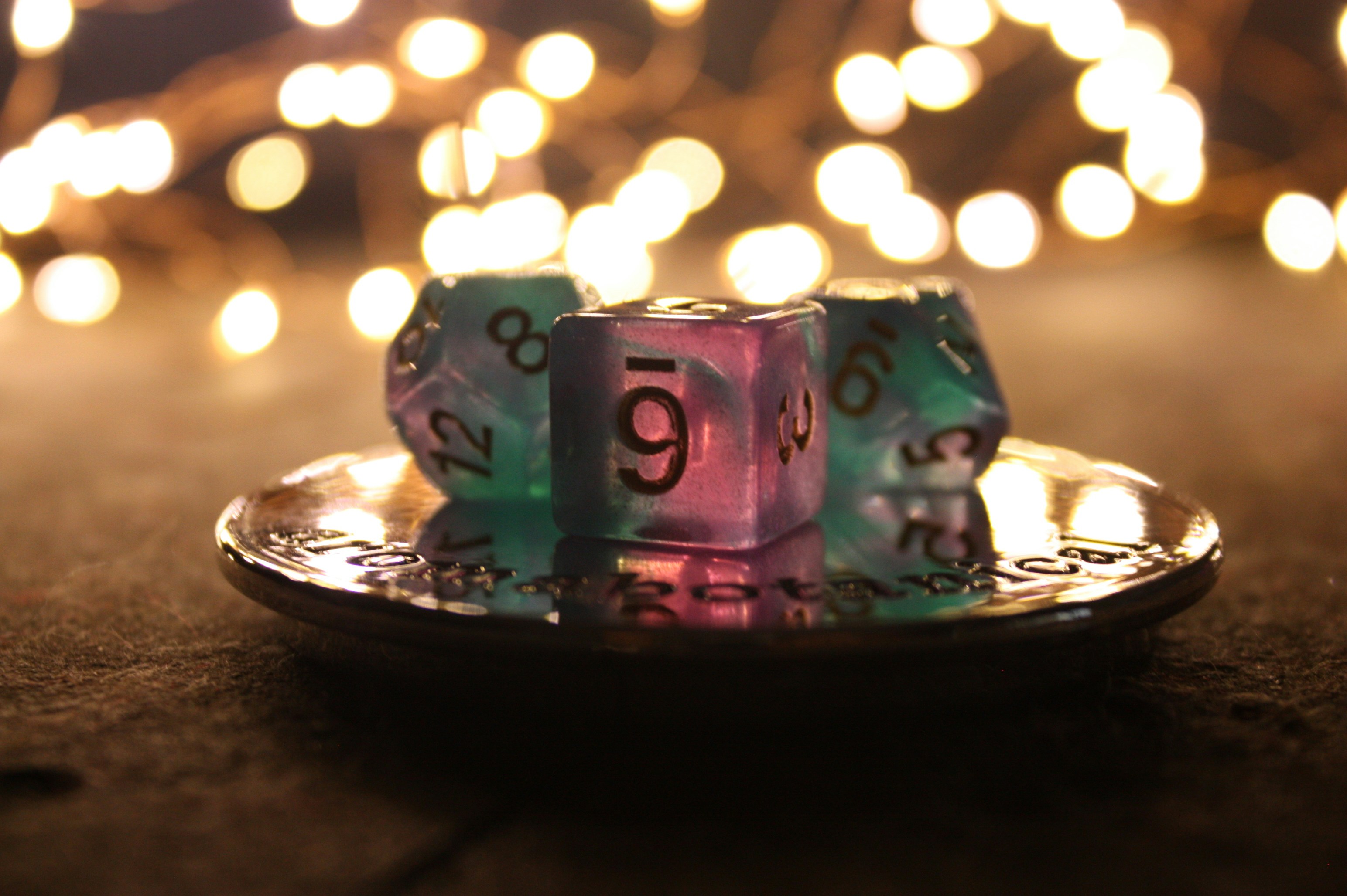 Dice sit in a dish with string lights in the background.