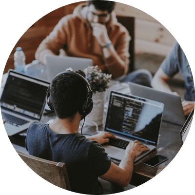 Individuals working on laptops in an open office.