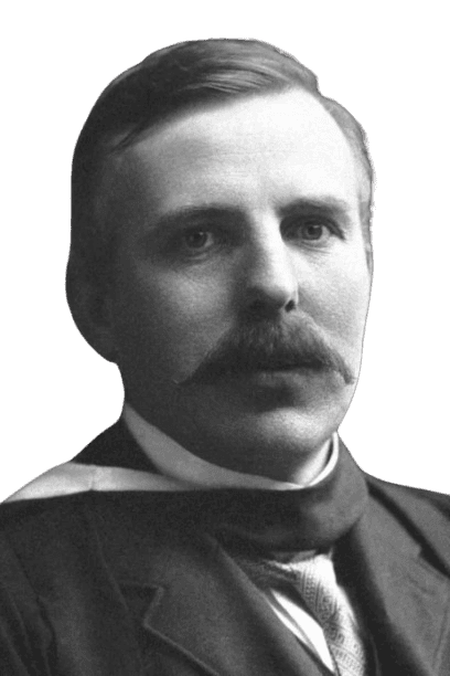 A vintage black-and-white portrait of a man with a thick mustache and neatly combed hair, wearing a formal suit and academic robe. His serious expression and classic attire suggest a scholarly or distinguished professional background, giving the image a timeless, dignified quality.