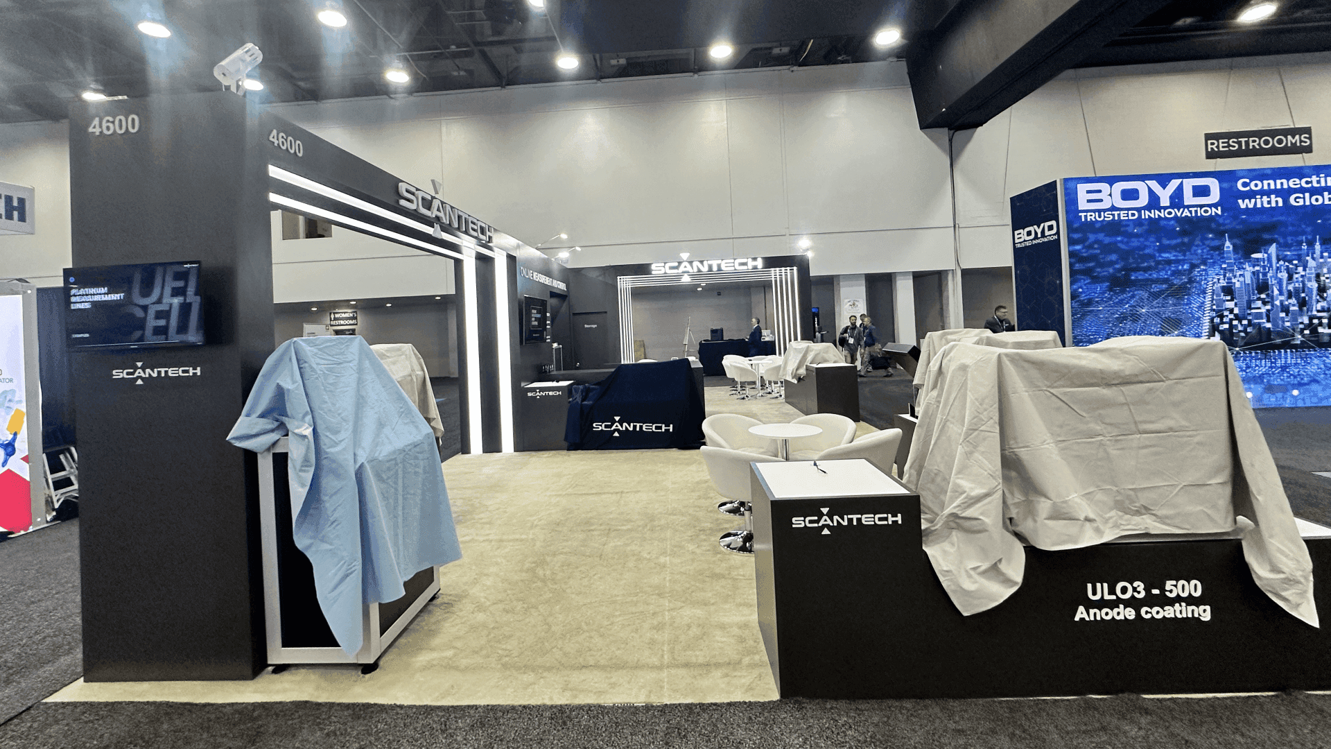 Front entry view showing SCANTECH portal frame, open walkway, and product counters prepared for battery manufacturing demos