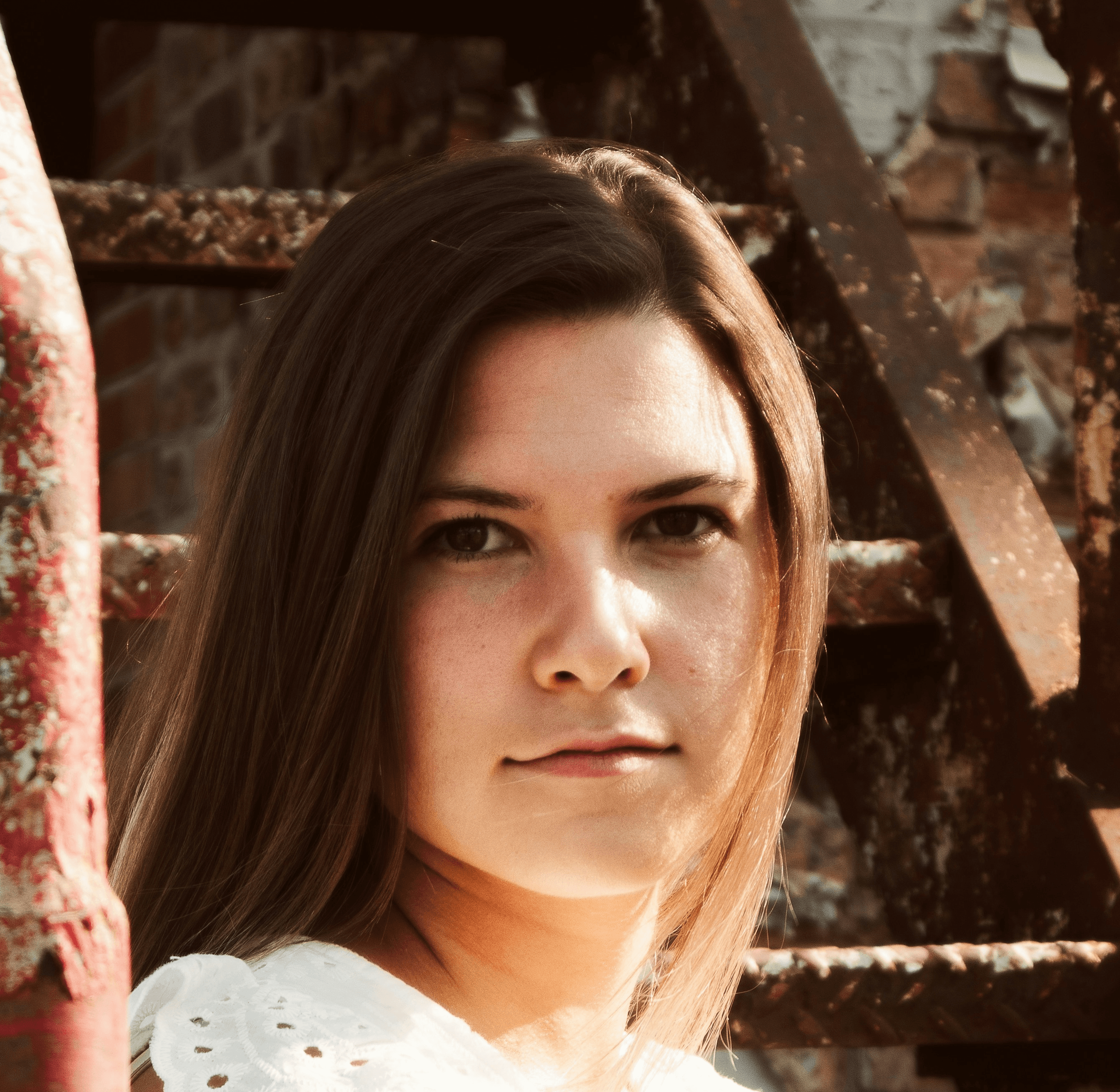 woman in white tank top leaning on red metal railings