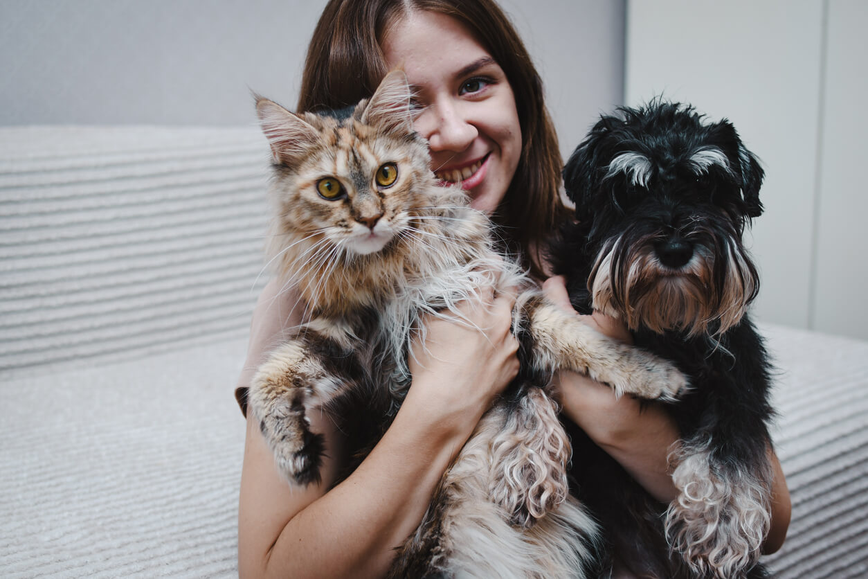 Woman holding a cat an a dog