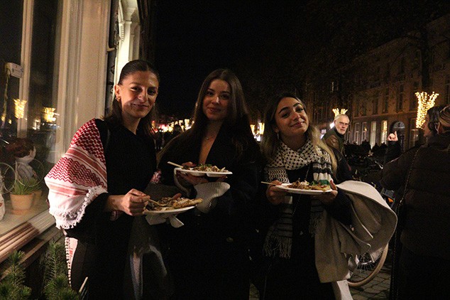 three ladies taking a picture infront of a restaurant