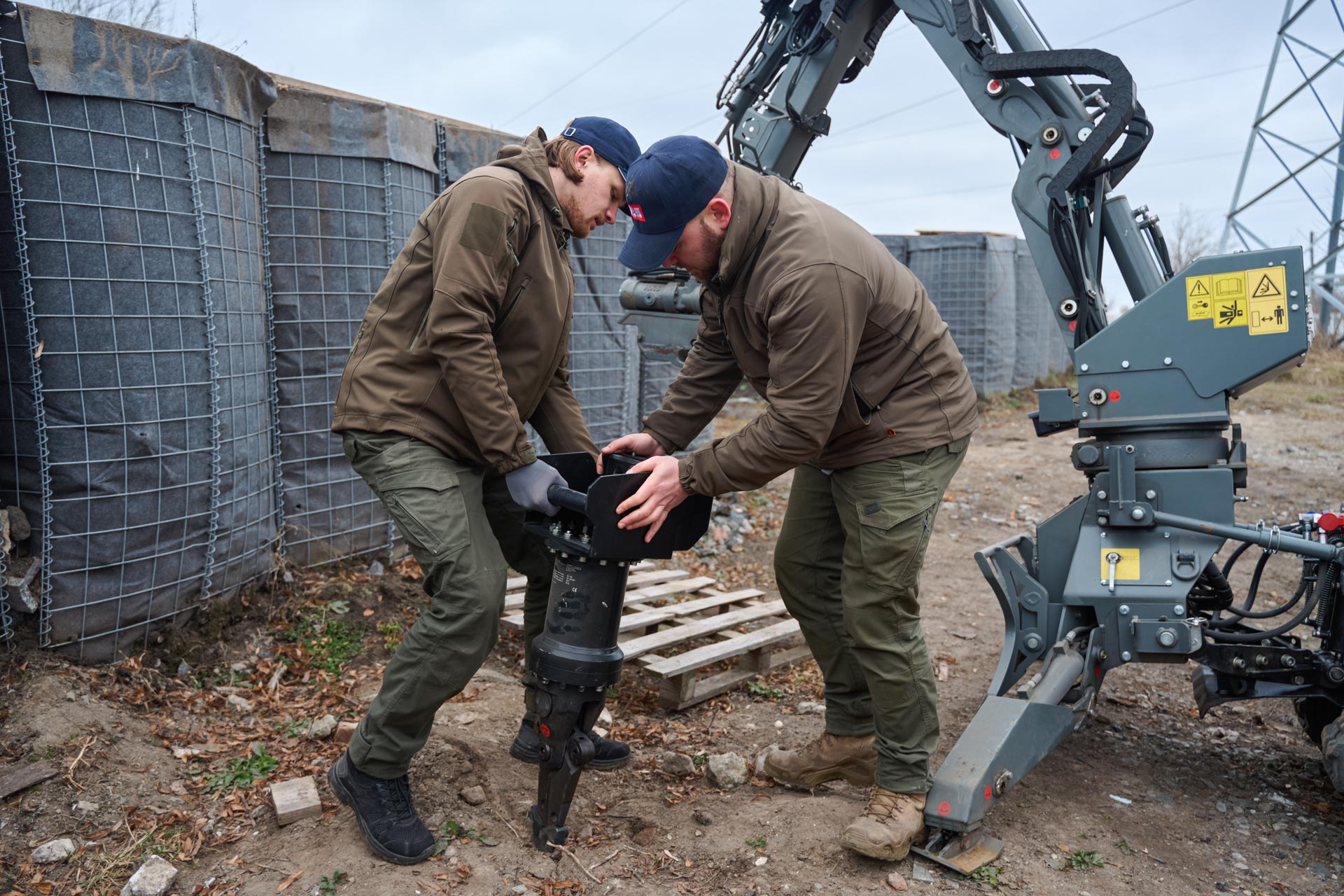 GCS technicians changing the manipulator arm tool to a shears spreader attachment during airfield clearance operations.