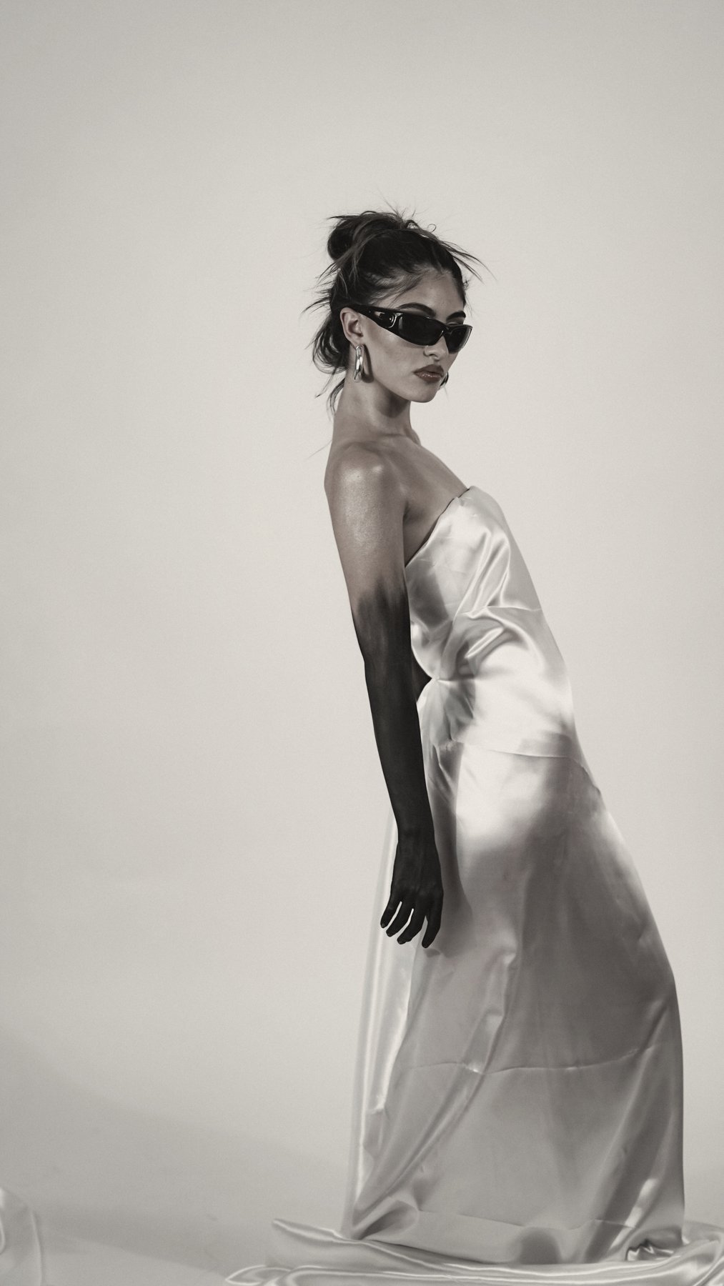 Model in a silver bias-cut slip dress and long black gloves