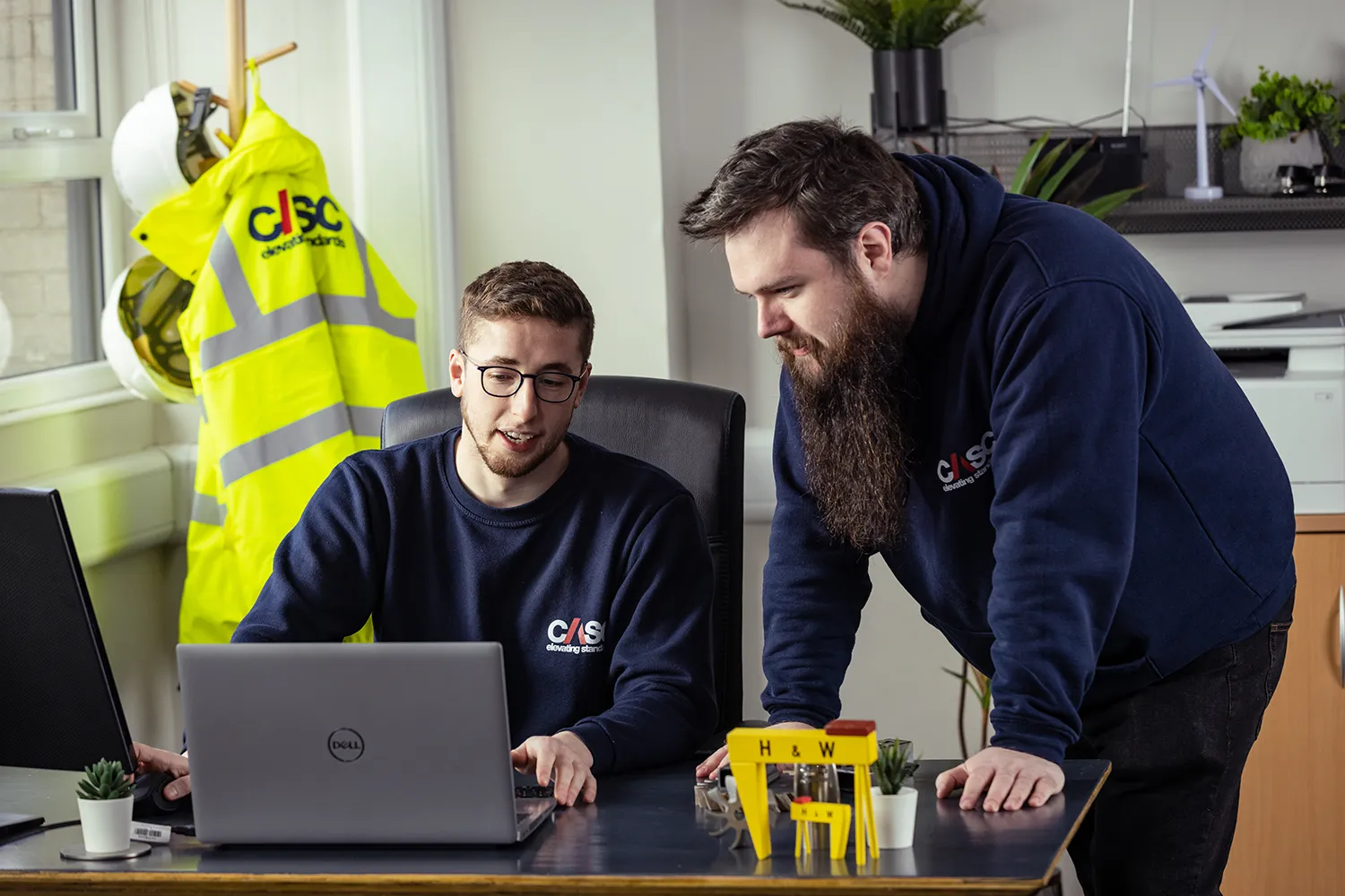 CASC employees’ service vans parked on site in front of offshore wind foundation structures during project delivery operations.