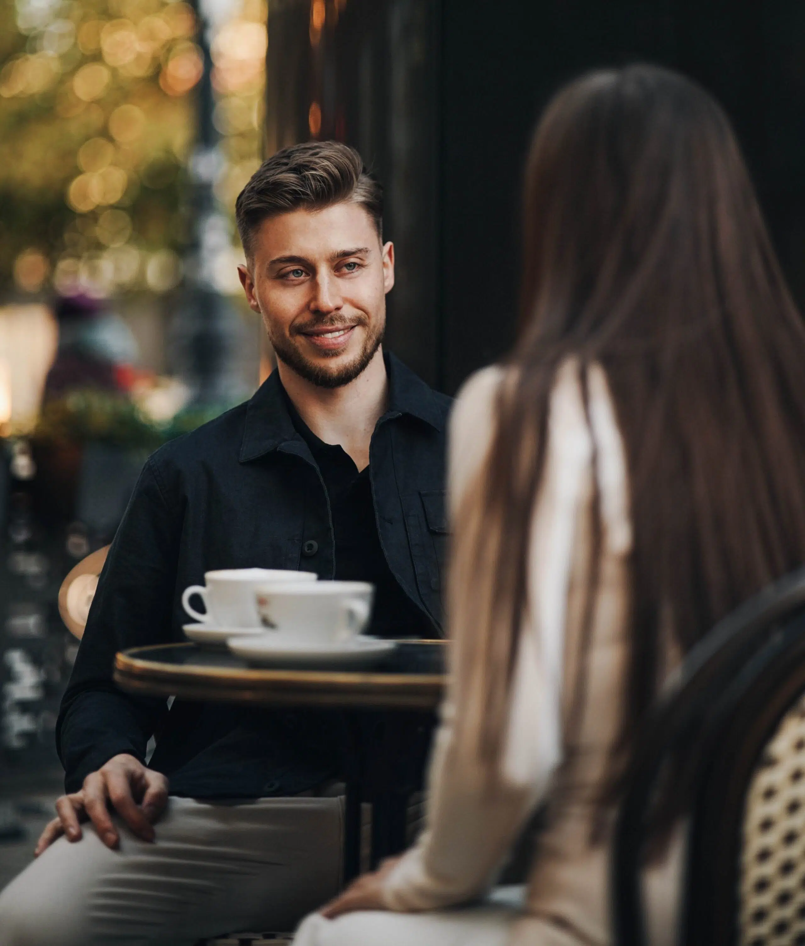 Mann und Frau sitzen im Café, unterhalten sich bei Kaffee. Dating oder Treffen?