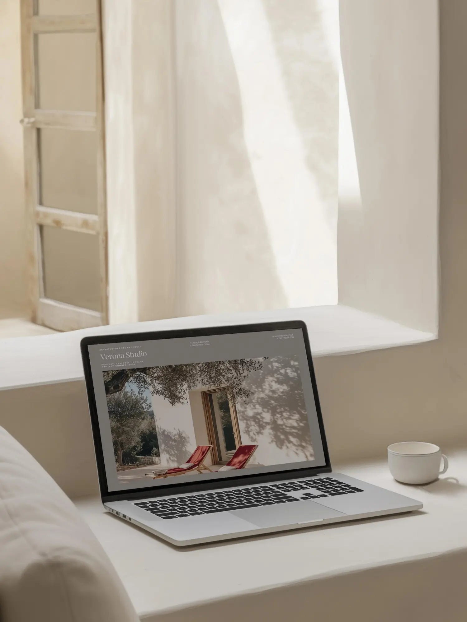 Laptop on a windowsill with a scenic display, next to a cup of coffee.