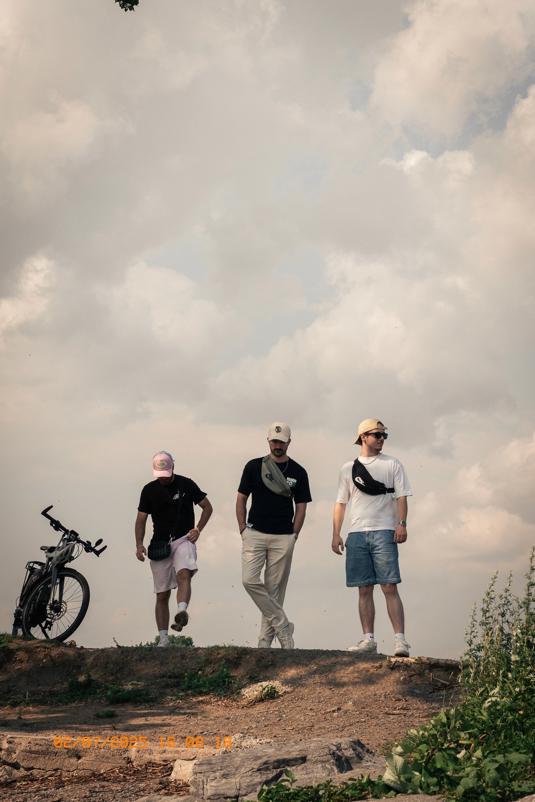Groupe d’amis sous un ciel nuageux, en promenade estivale.