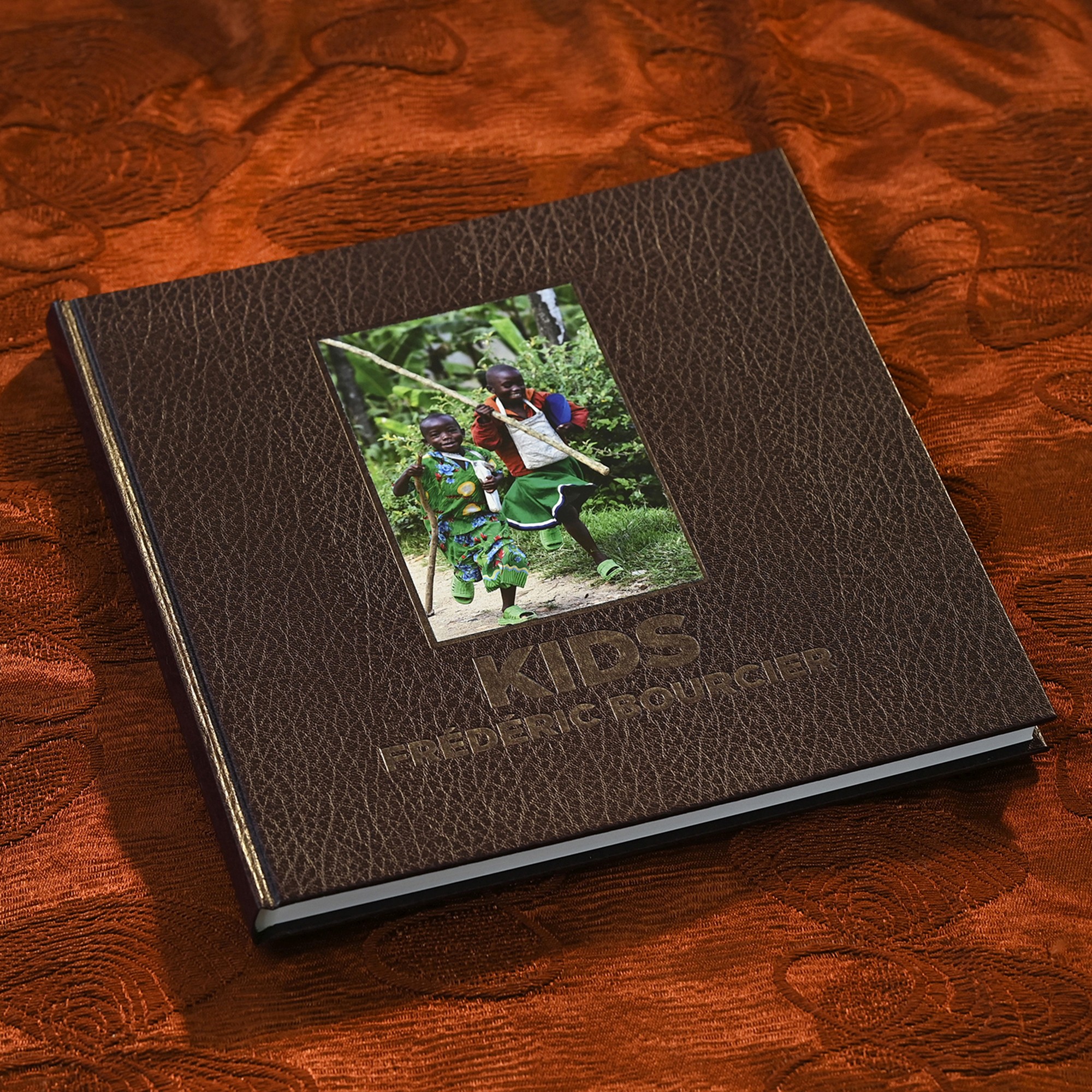 Livre photo Kids de Frédéric Bourcier, à couverture marron avec une photo d’enfants jouant à la balançoire.