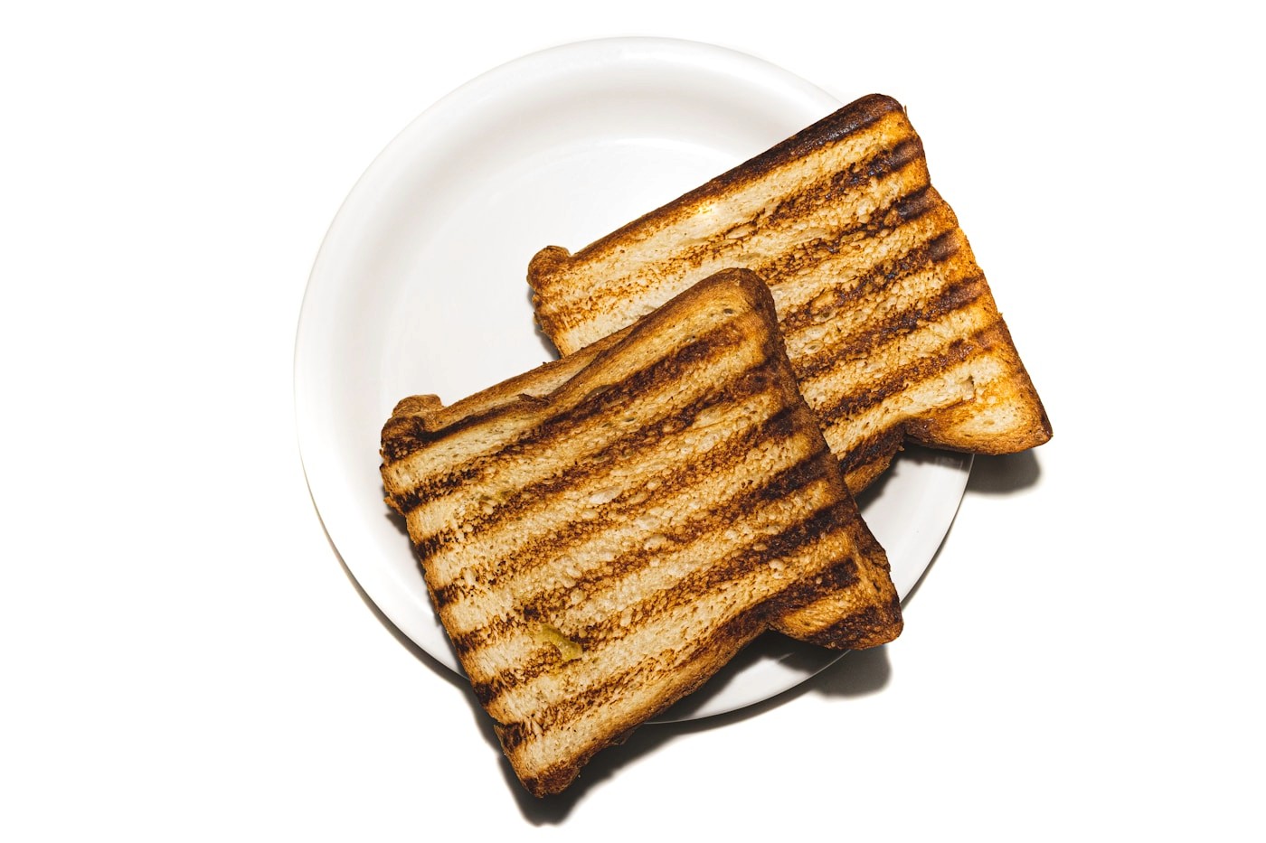 Plain toasted bread on a white plate, an example of the bland, low-effort foods that are gentle on the roughest, most nauseated days.