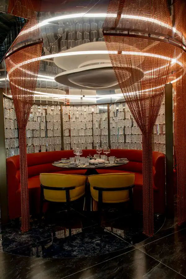 Round alcove, velvet banquette and a ring of copper light