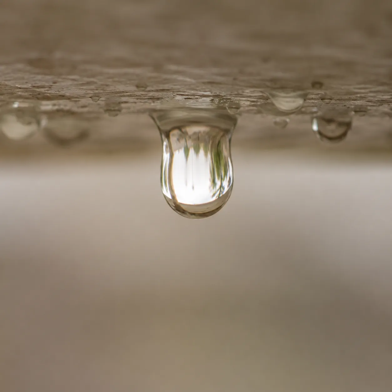 Wassertropfen hängt an einer feuchten Oberfläche