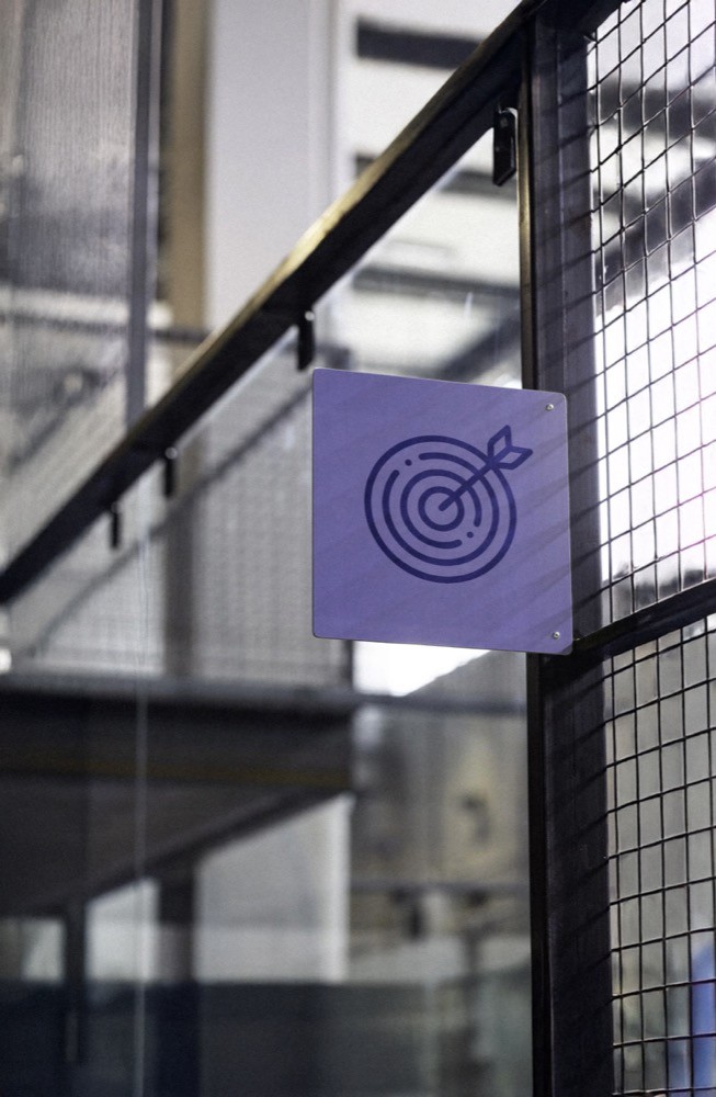 Lilanes Schild mit Zielscheiben-Symbol hängt an der Glaswand eines Padelcourts – modernes, klares Design im Stil von Padelnero