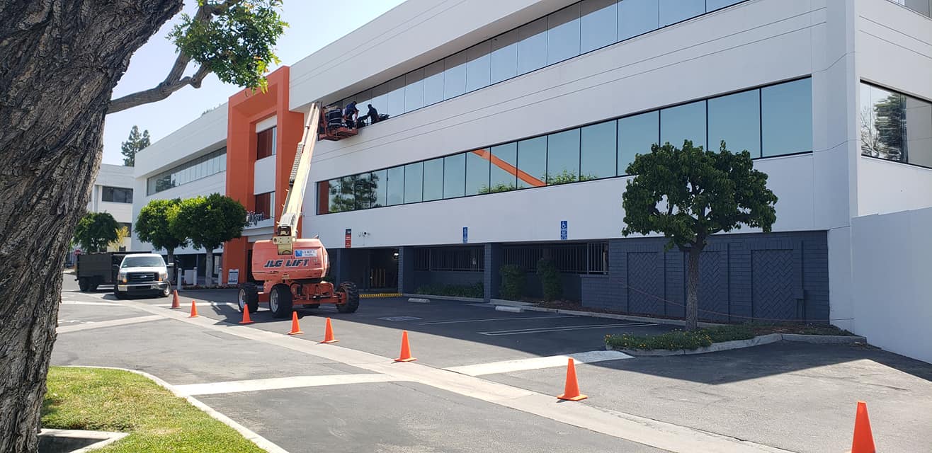 bottom view shot of airplane flying above high rise building