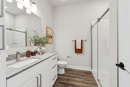 A modern bathroom featuring white cabinets and a spacious walk-in shower.