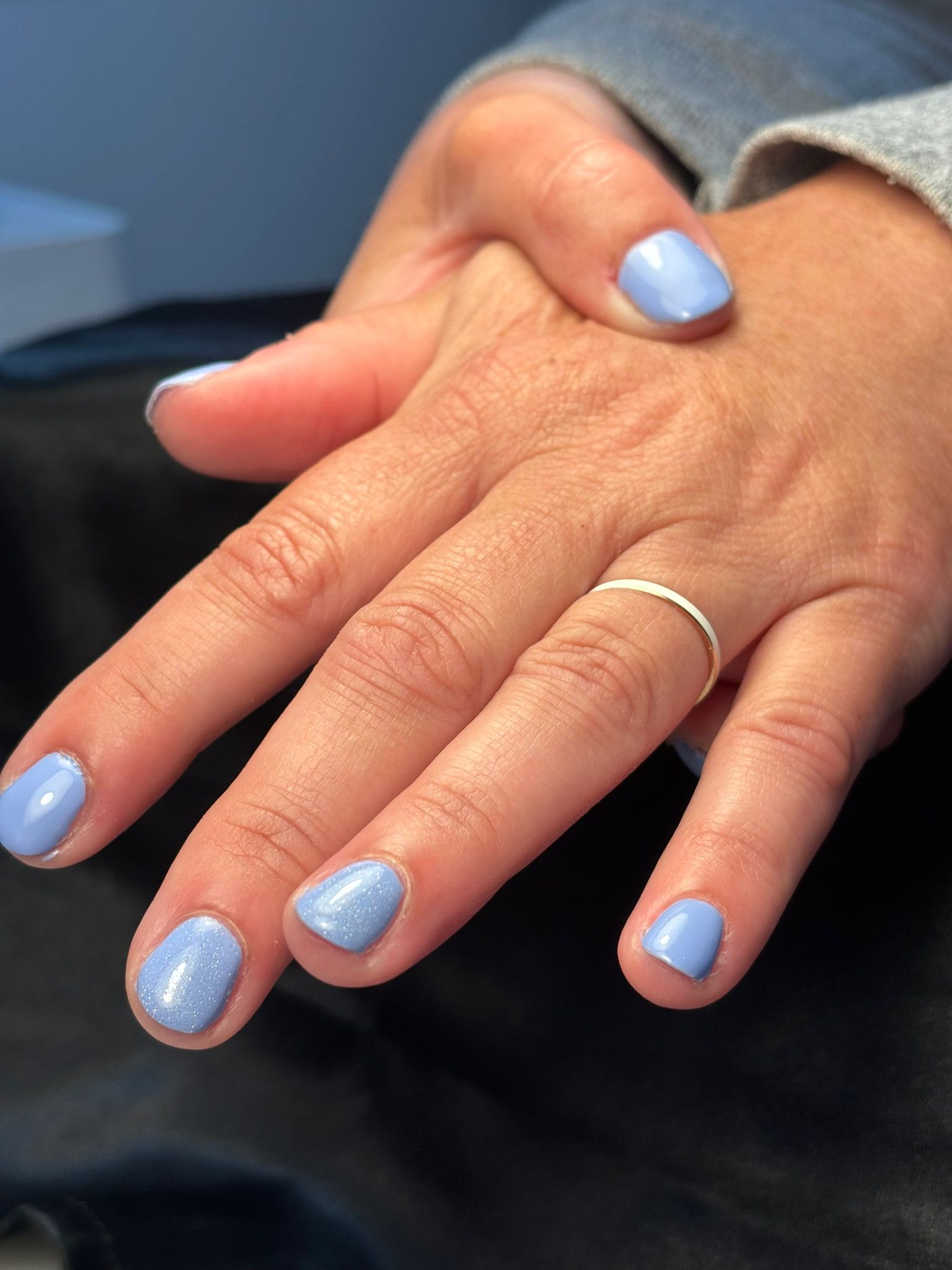 person with pink manicure on white textile