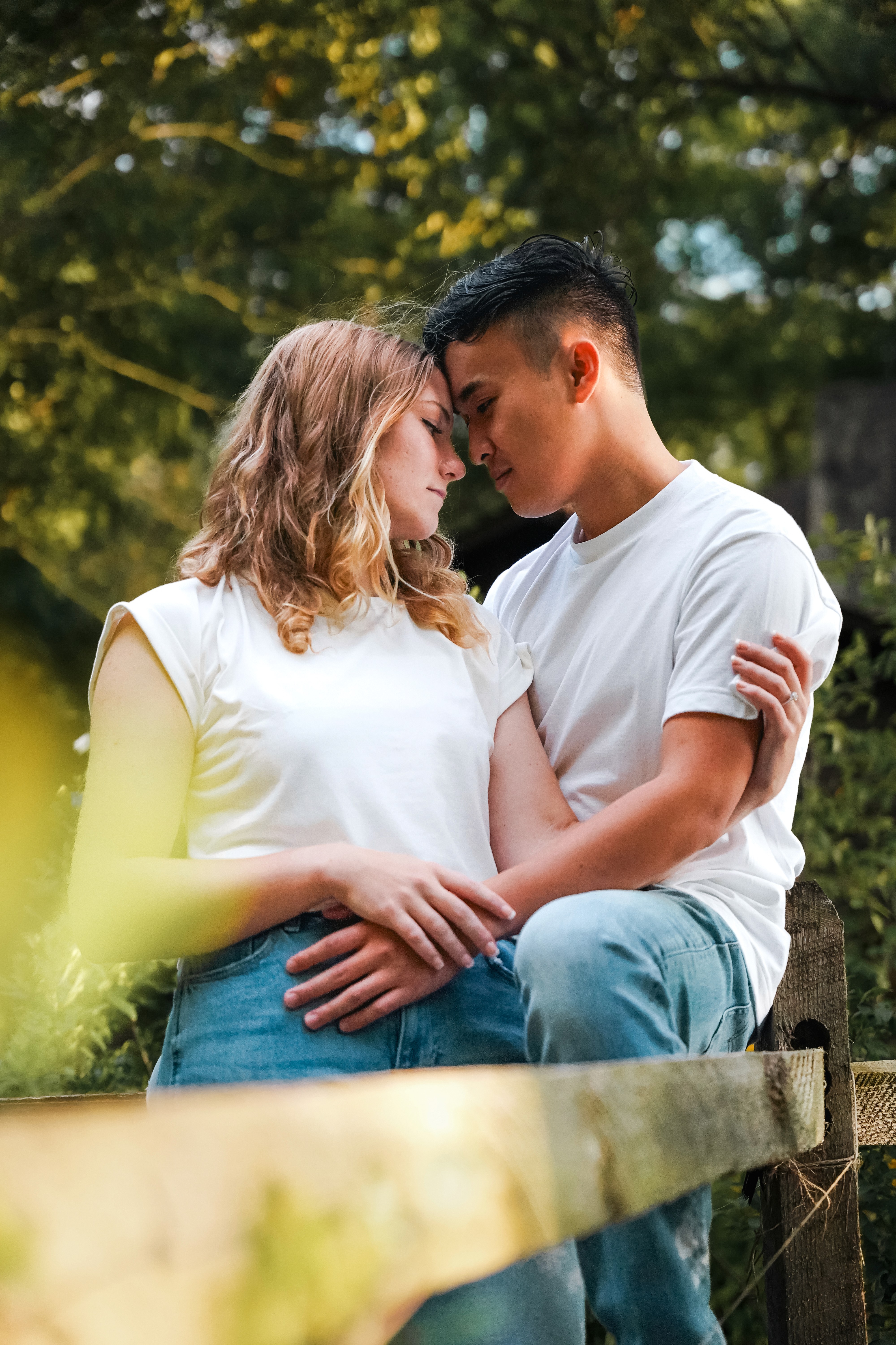 A couple stands hand-in-hand in front of a rustic stone building.
