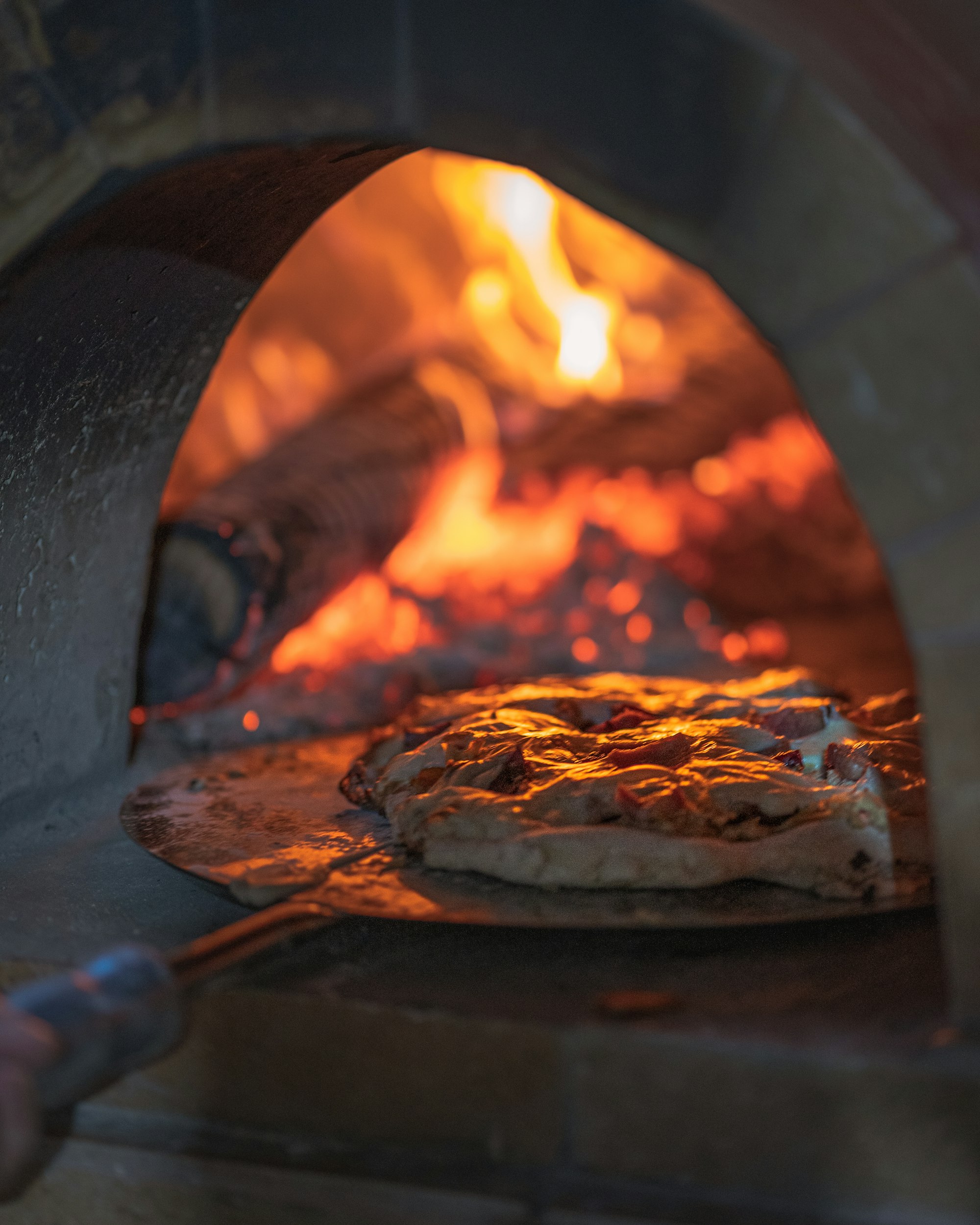 Loaves baking on the stone of a wood-fired oven