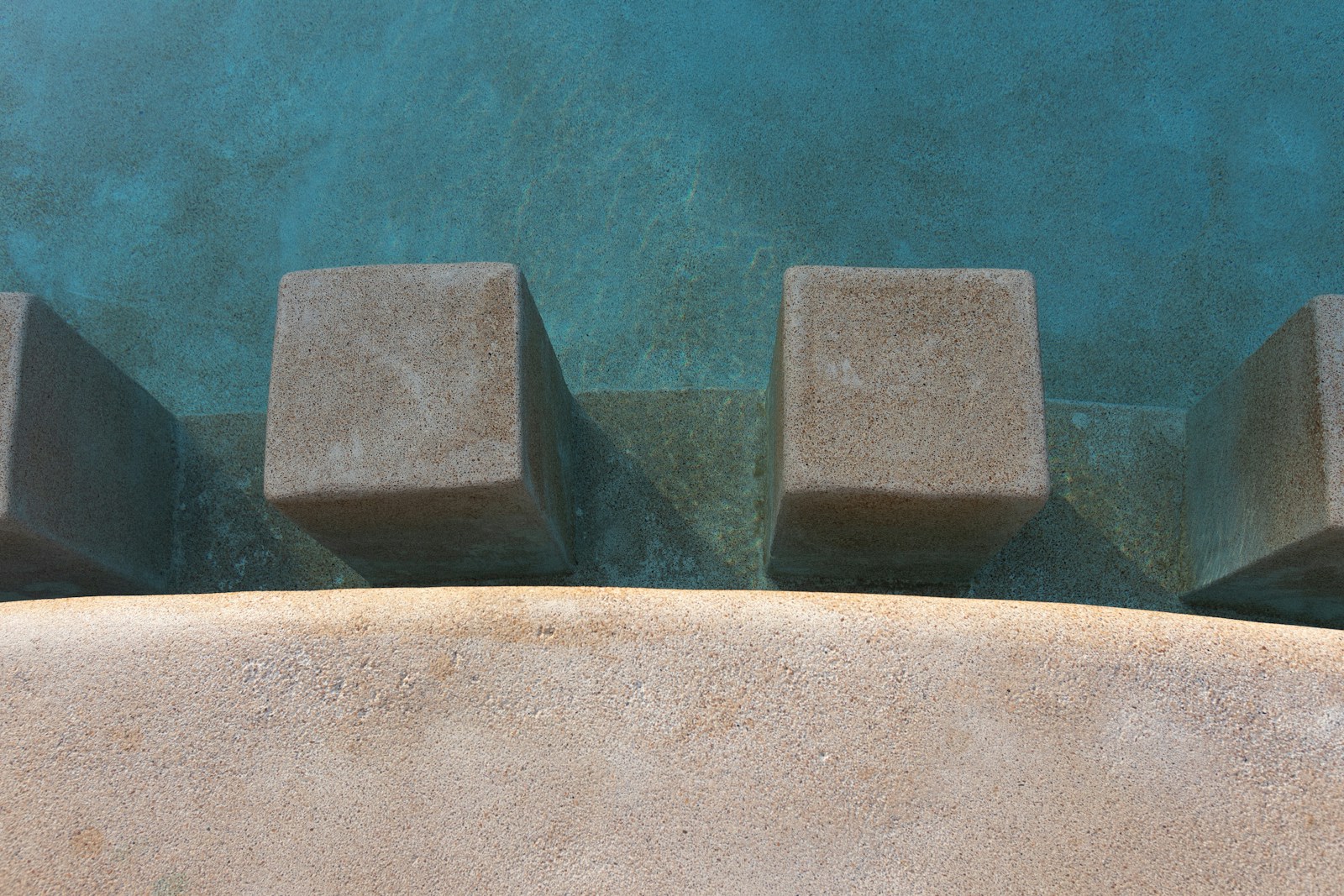 Graphic pool geometry with concrete blocks and blue water