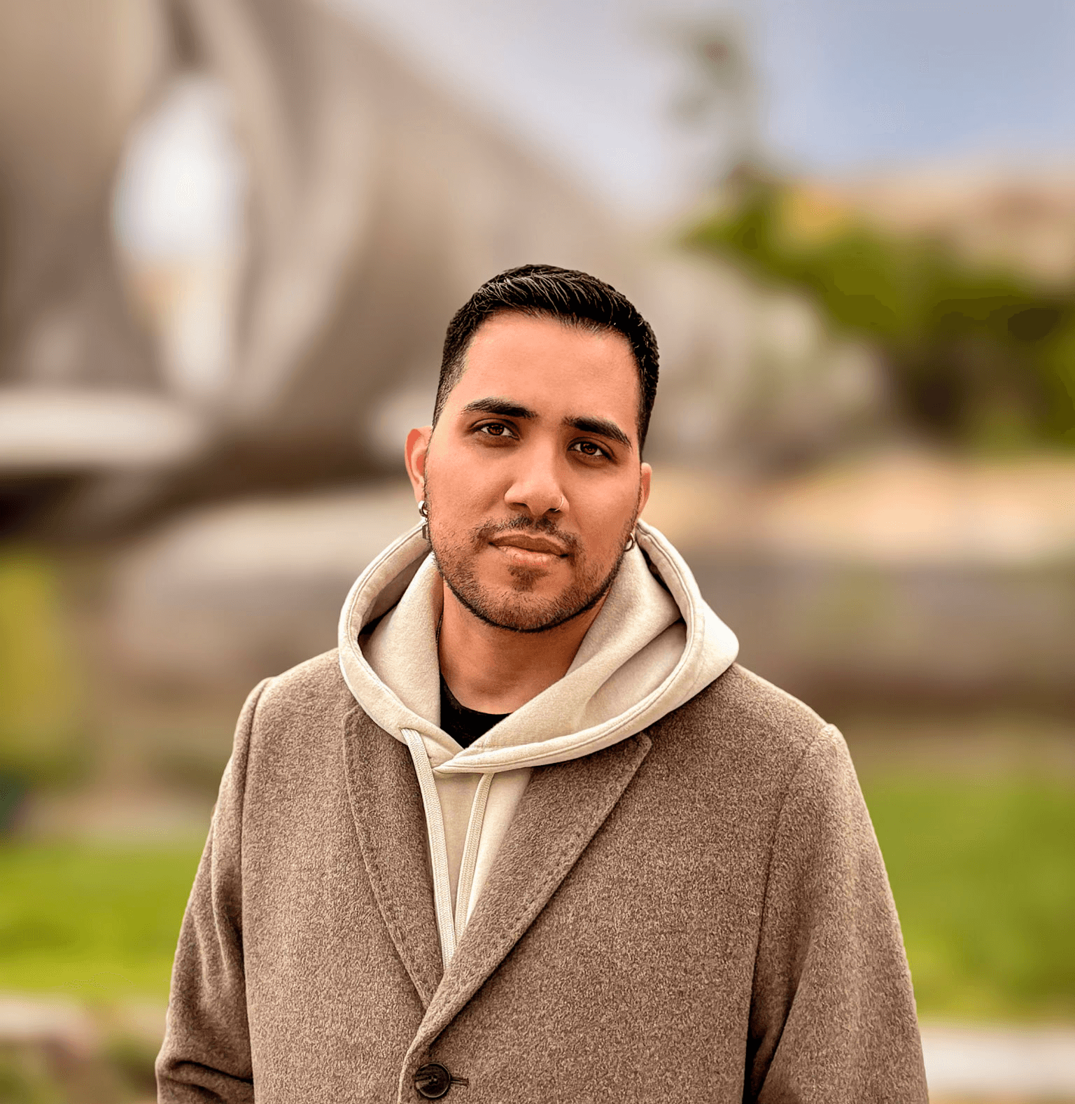 Designer Brayan angulo looking to the right with a blur beach background