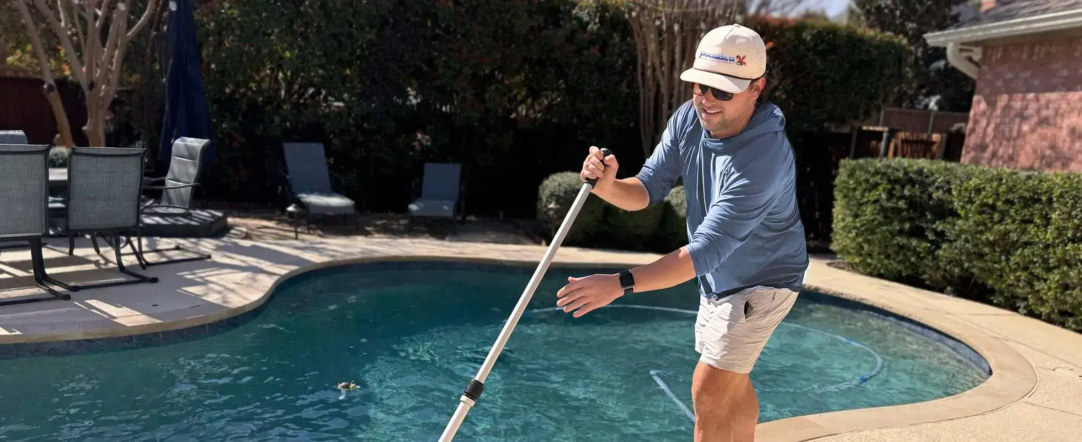 Grand Prairie Pool service technician from Poolside, TX cleaning pool
