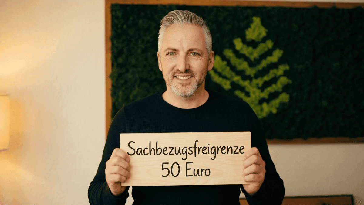Hannes Weidnorf hält ein Schild mit der Aufschrift: Sachbezugsfreigrenze 50 EUR — Was zählt rein?