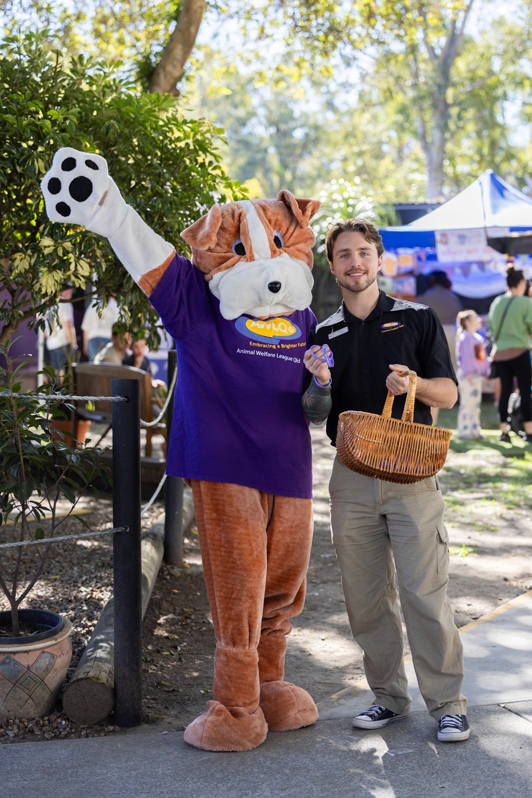 Dog mascot with young man holding basket