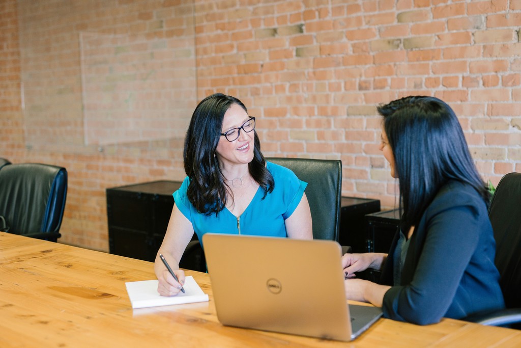 Two women facing each other talking.