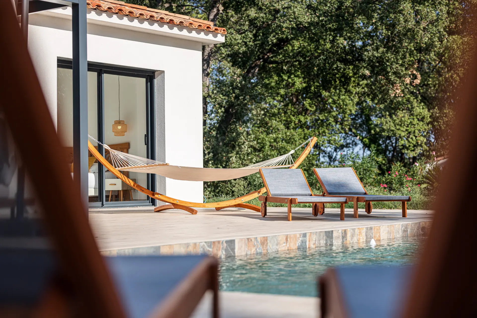 Photographie du bord d'une piscine avec hamac