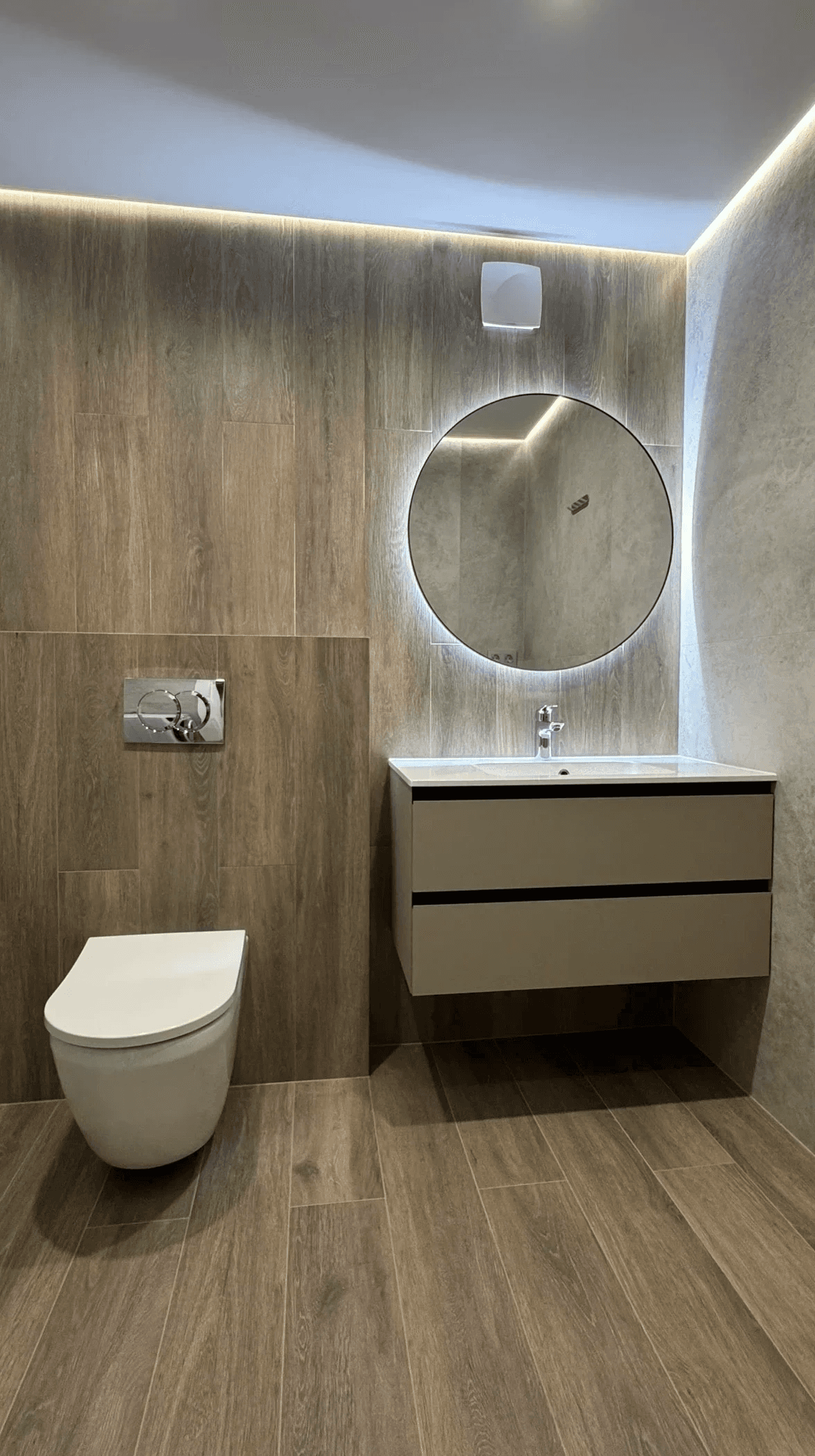 Санвузол з круглим дзеркалом, підвісною тумбою і дерев’яною плиткою