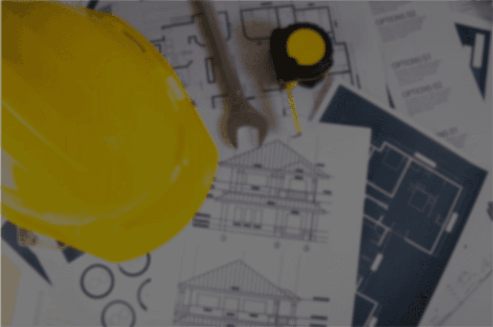 Casque de sécurité jaune et plans de bâtiment sur une table