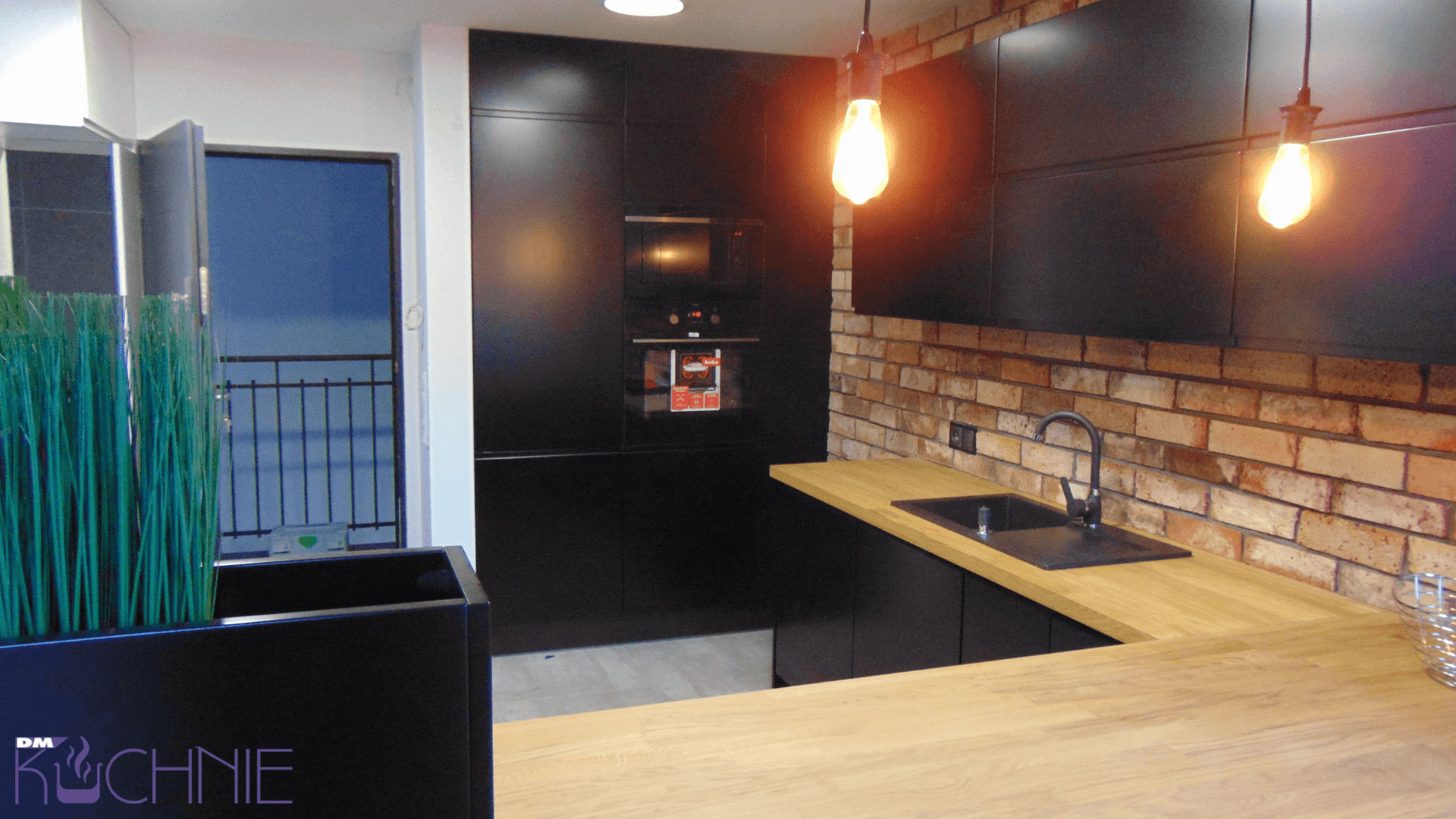 Meble kuchenne na wymiar w Warszawie – czarna zabudowa z piekarnikiem i drewnianym blatem