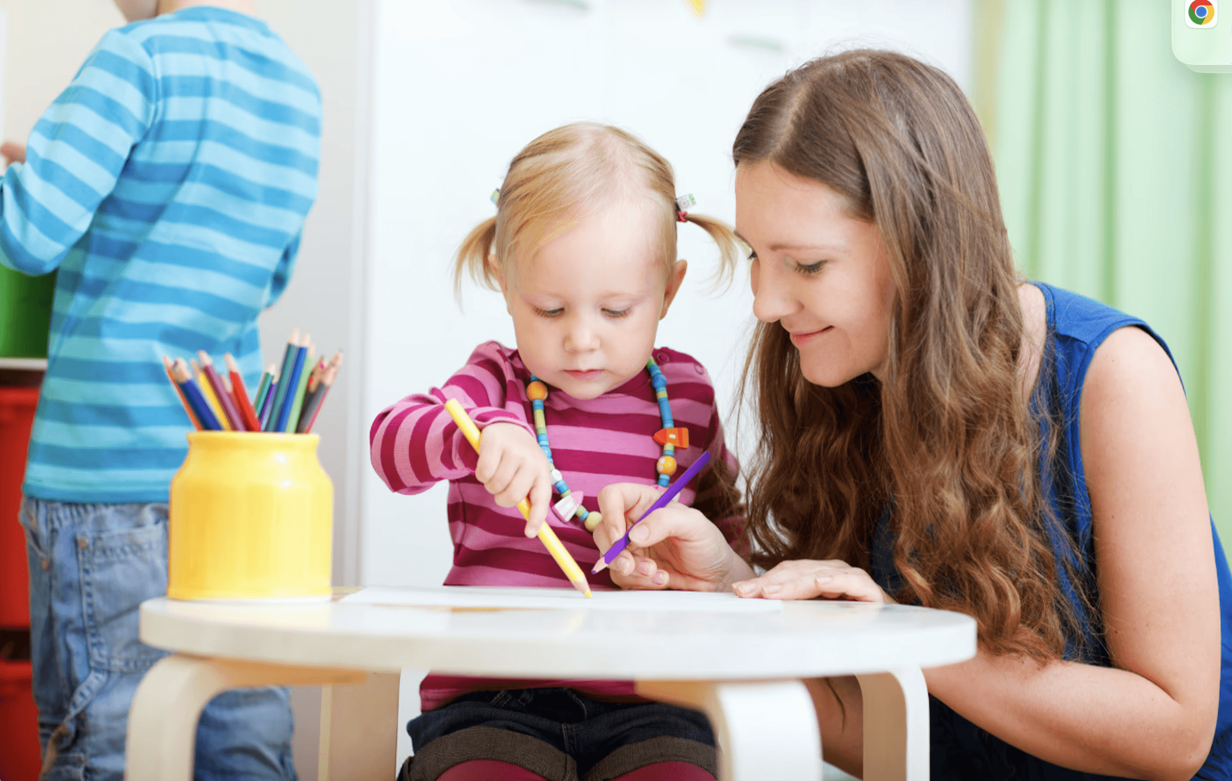 woman watching young girl using pencil
