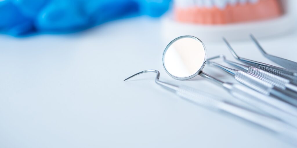A dental mirror and probe on a tray