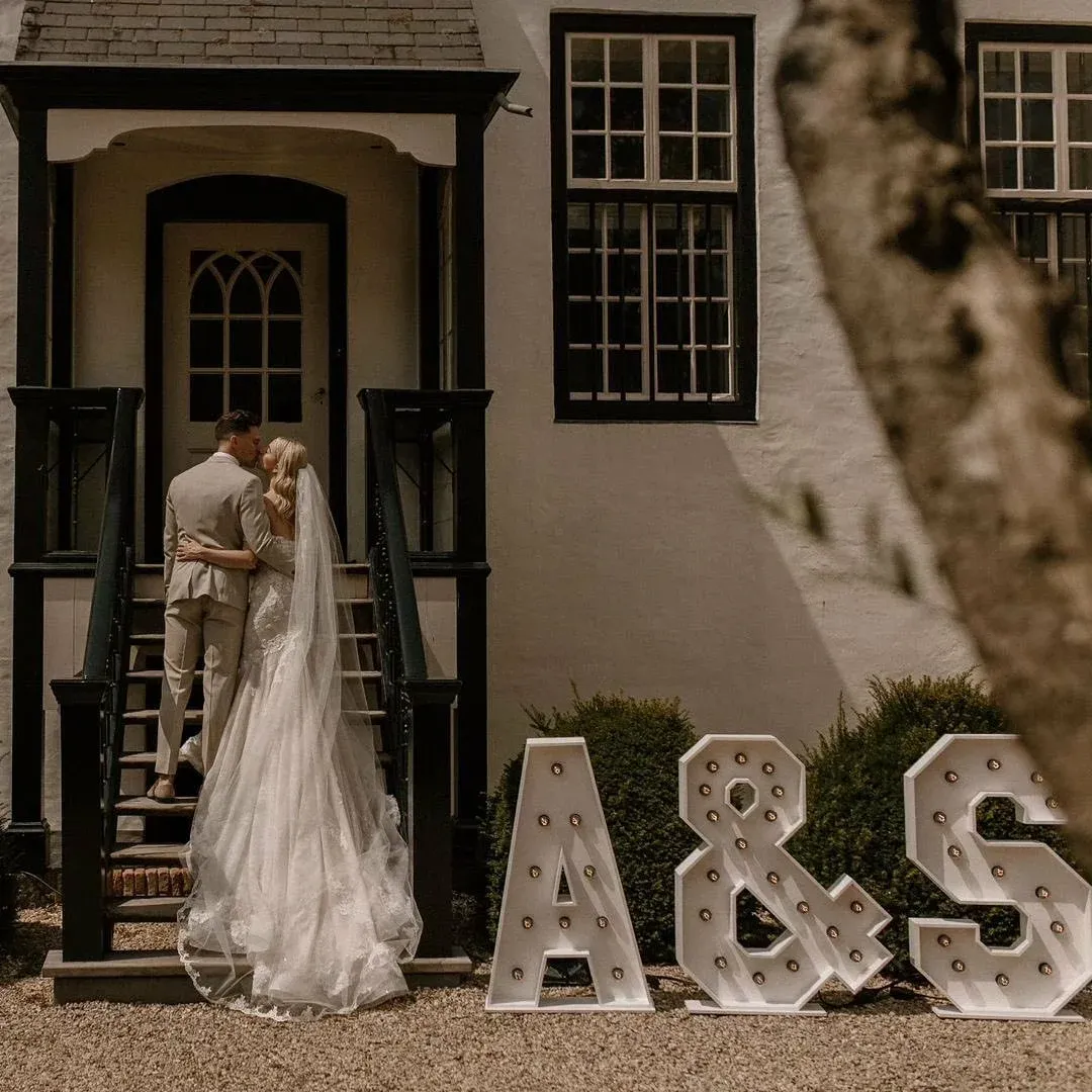 Bruidspaar met 3 lichtletters, hun initialen A&S