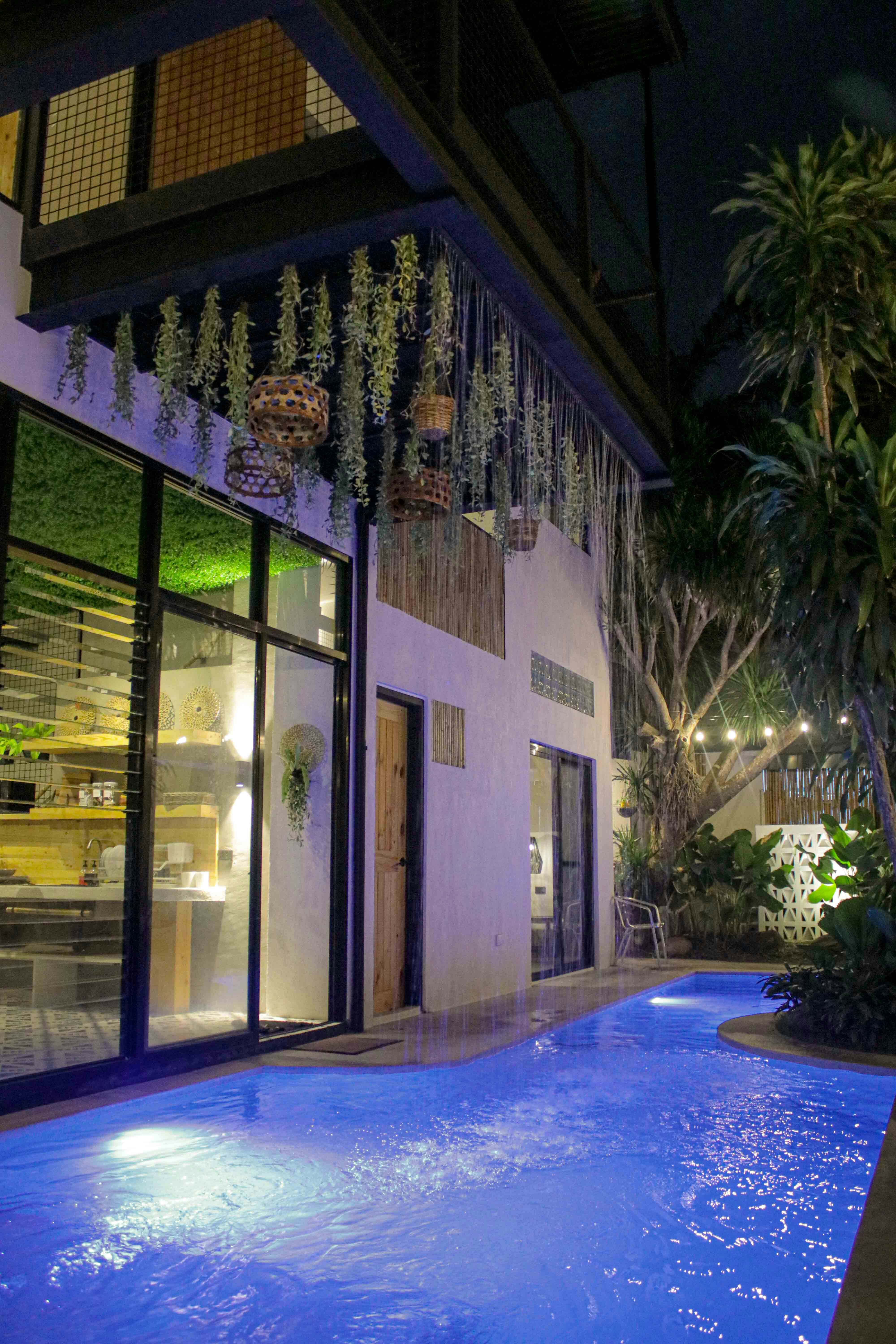a swimming pool in front of a building at night
