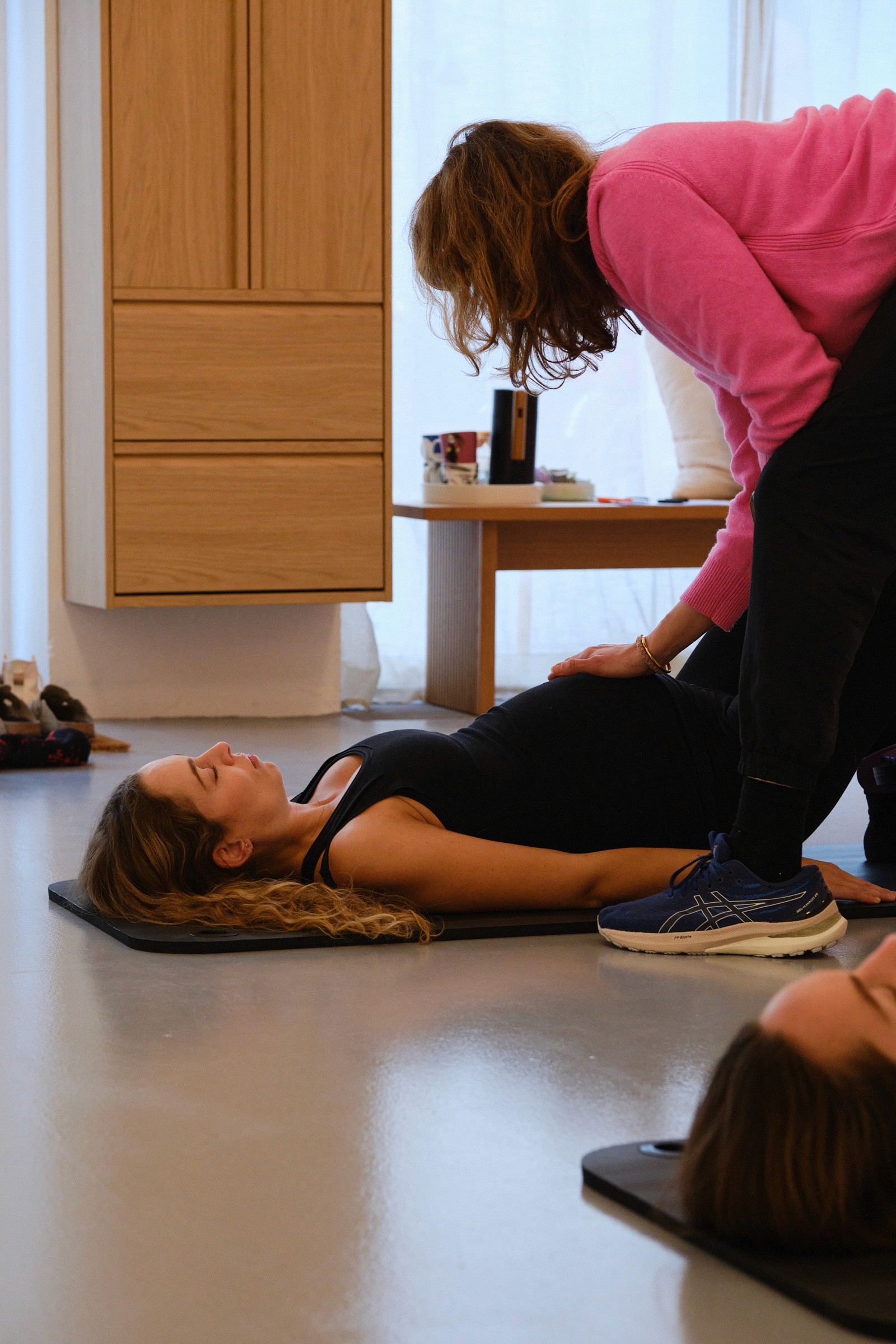 Gravid kvinde bliver guidet igennem en pilates øvelse