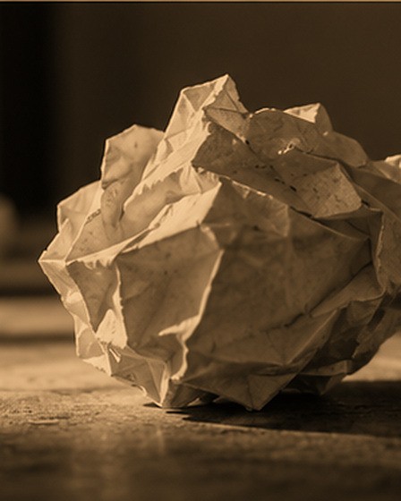 A discarded draft, crumpled, among others